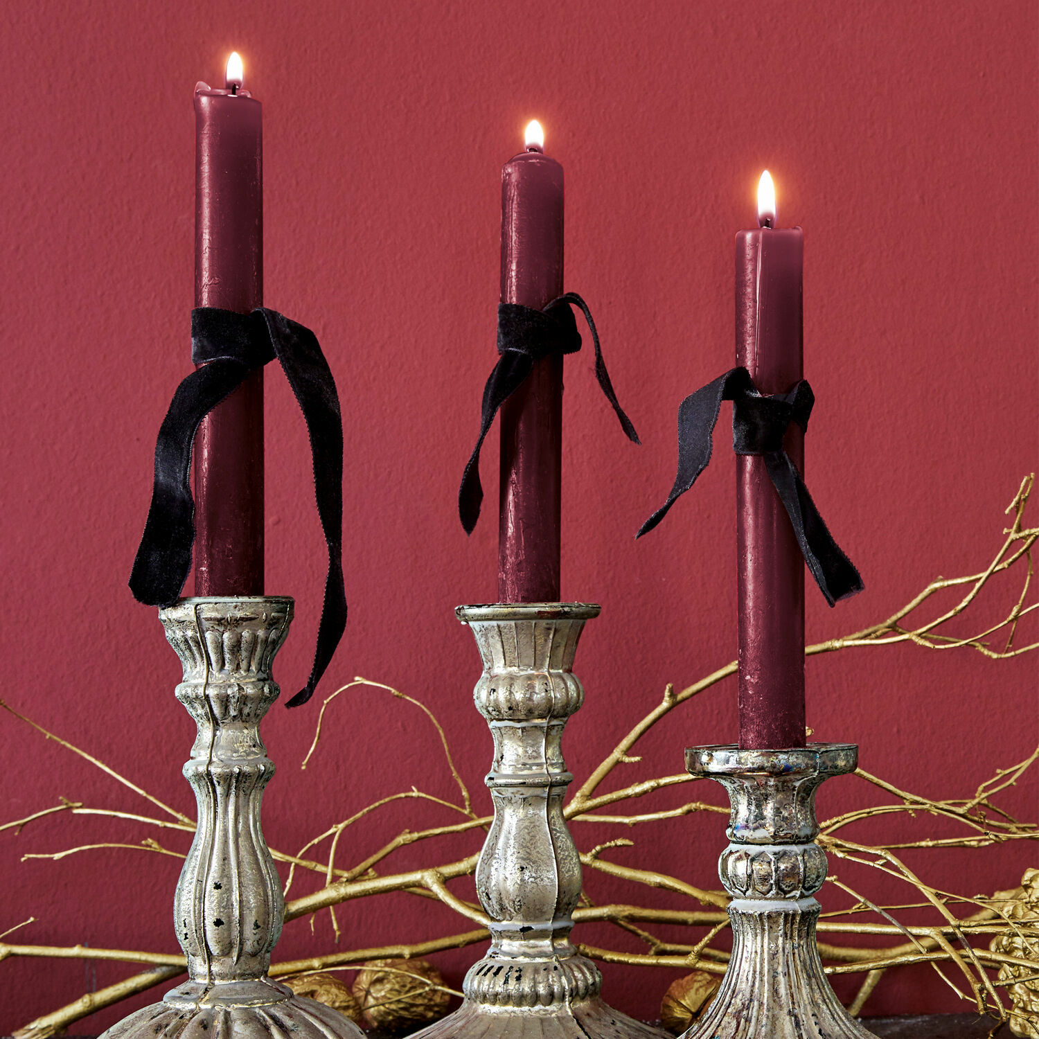 Lot de 12 bougies Bauceau Trois bougeoirs en métal argenté avec bougies bordeaux et rubans noirs sur fond rouge