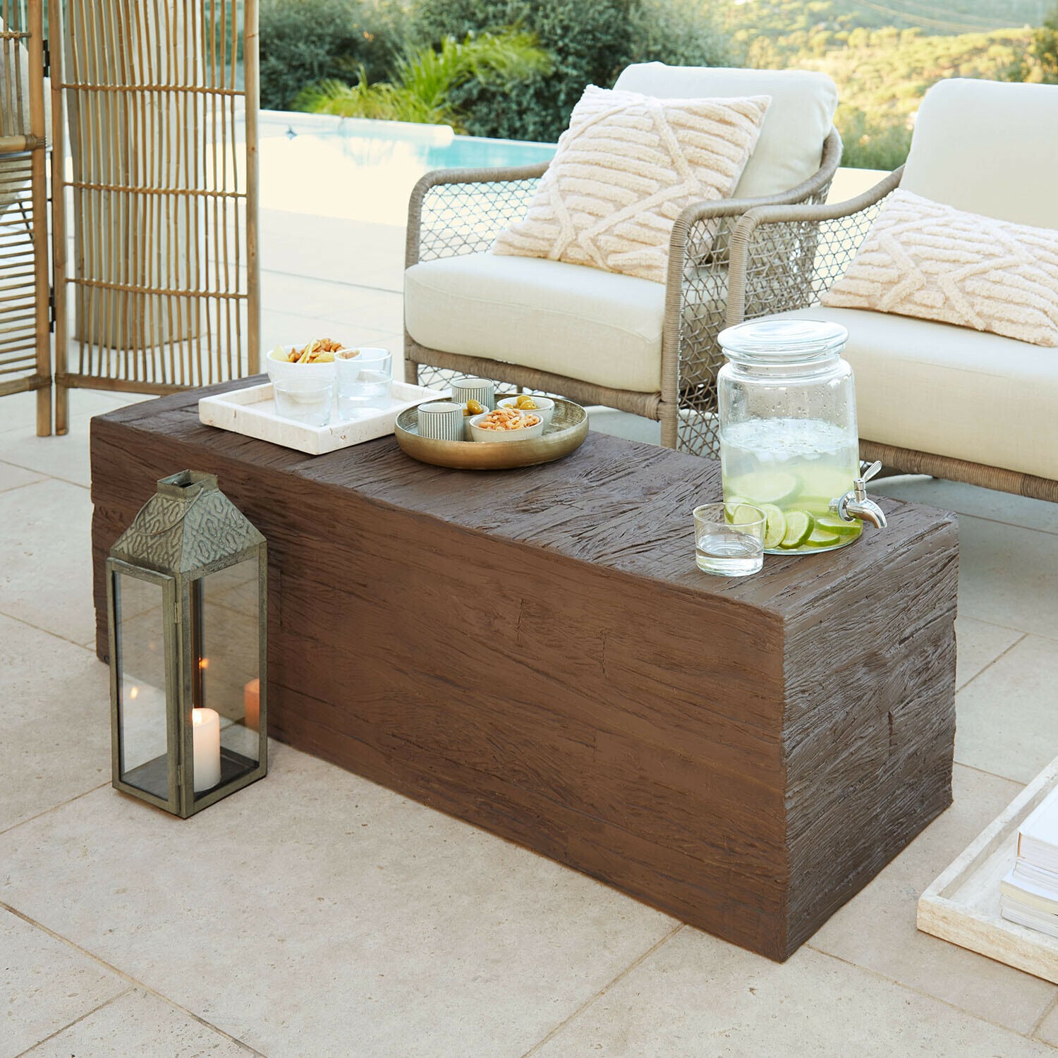 Table basse Fenwarden Table basse marron effet bois sur terrasse avec coussins crème et carafe de citronnade