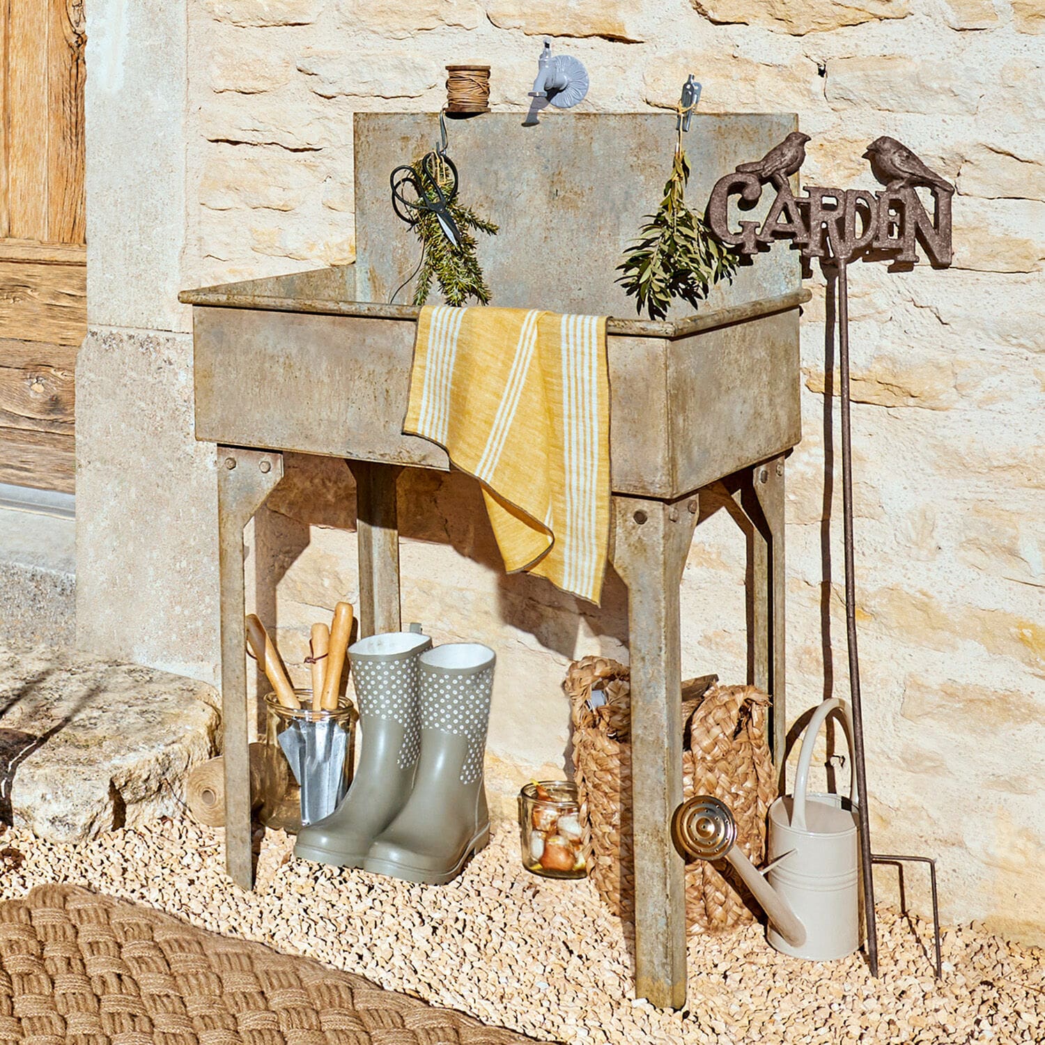 Évier extérieur Lison Évier de jardin en métal gris avec outils et bottes en caoutchouc sur sol gravillonné