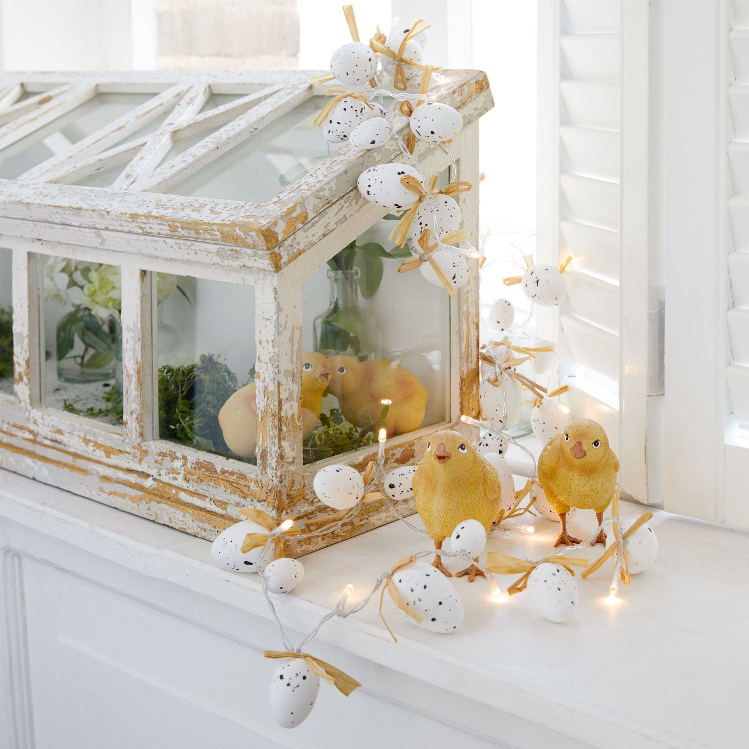 Lot de 2 guirlandes lumineuses Mikka Guirlande décorative d'œufs blancs avec nœuds et poussins jaunes sur rebord de fenêtre blanc
