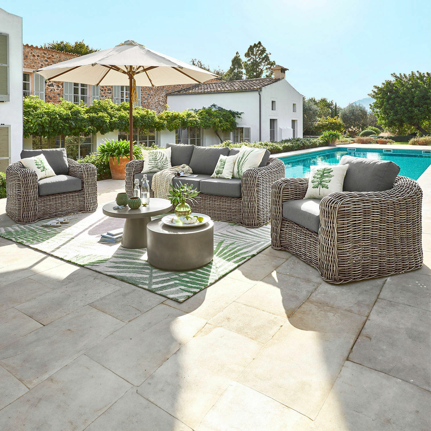Salon de jardin Upminster Ensemble de mobilier de jardin en technorattan gris avec coussins et parasol au bord de la piscine