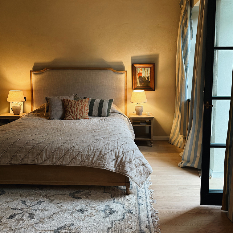 Chambre chaleureuse avec lit en bois, couette beige et lampes sur tables de chevet en bois