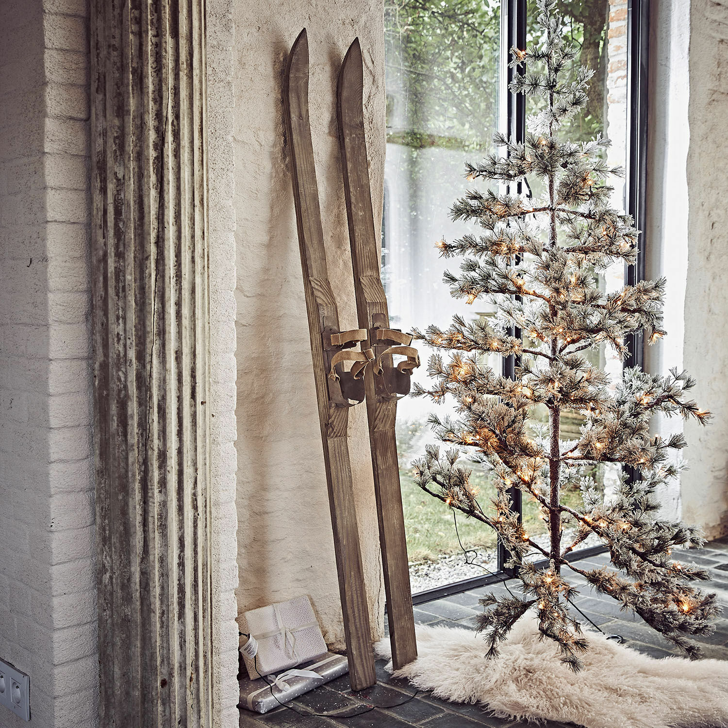 Lot de 2 skis décoratifs Lambeth Paires de skis en bois vintage près d'un sapin artificiel éclairé avec tapis blanc au sol
