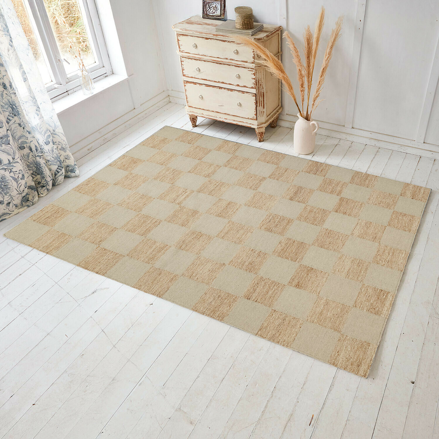 Tapis Nexari Tapis beige à carreaux en matériau naturel sur un sol en bois clair dans une pièce lumineuse