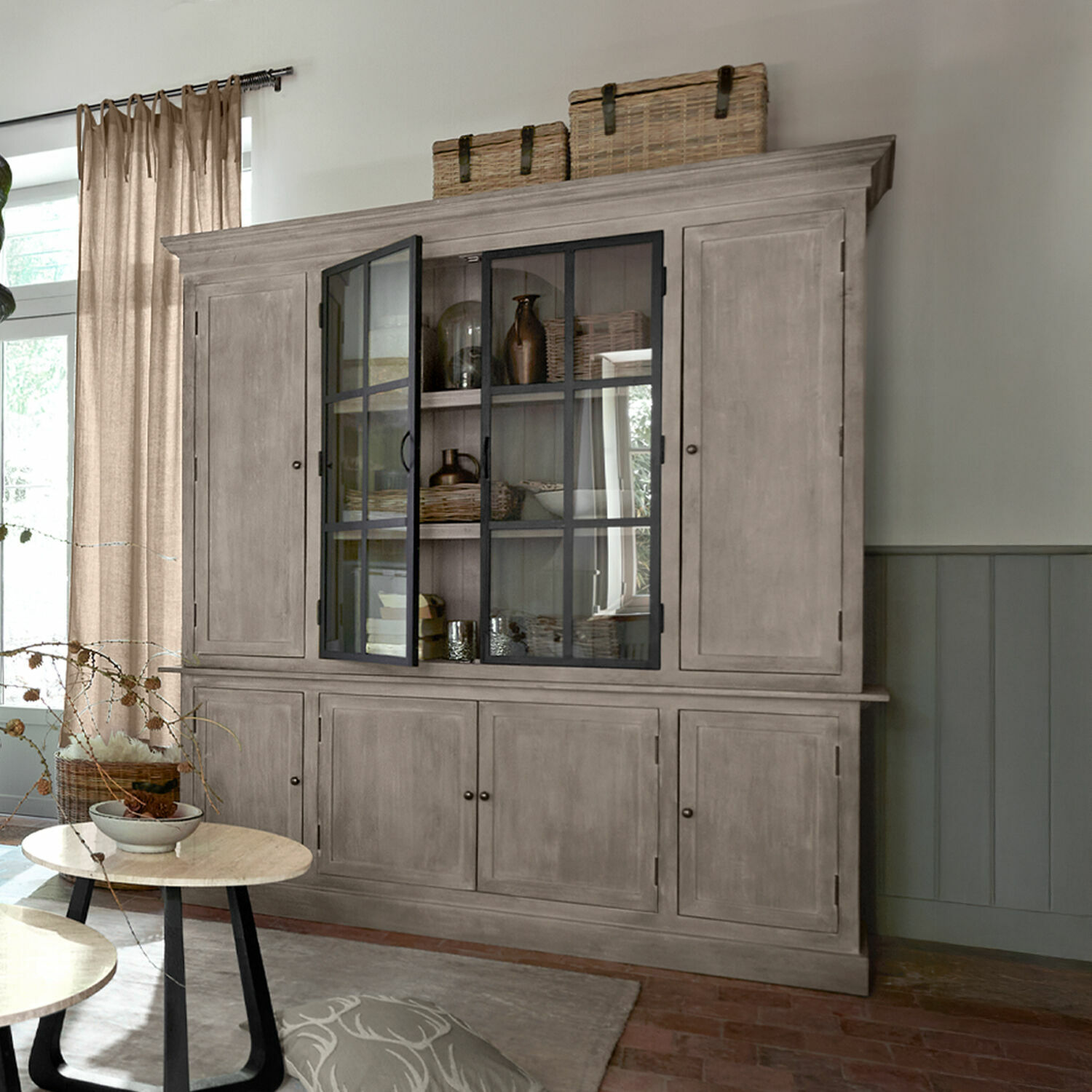 Vaisselier Valandor Grande vitrine en bois gris avec portes vitrées et paniers sur le dessus dans un salon