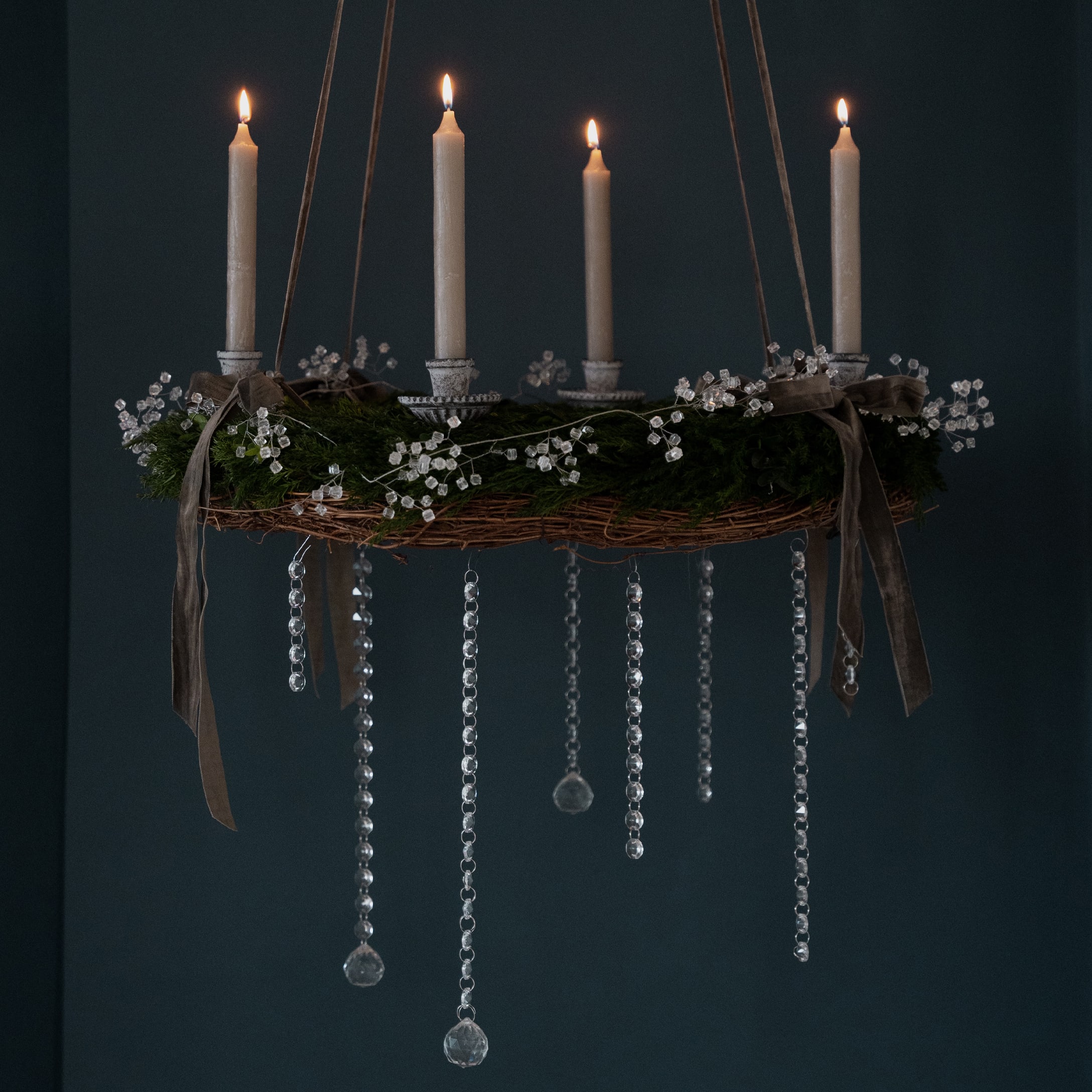 Couronne de l'Avent suspendue avec branches vertes, bougies blanches et décorations en cristal pour Noël