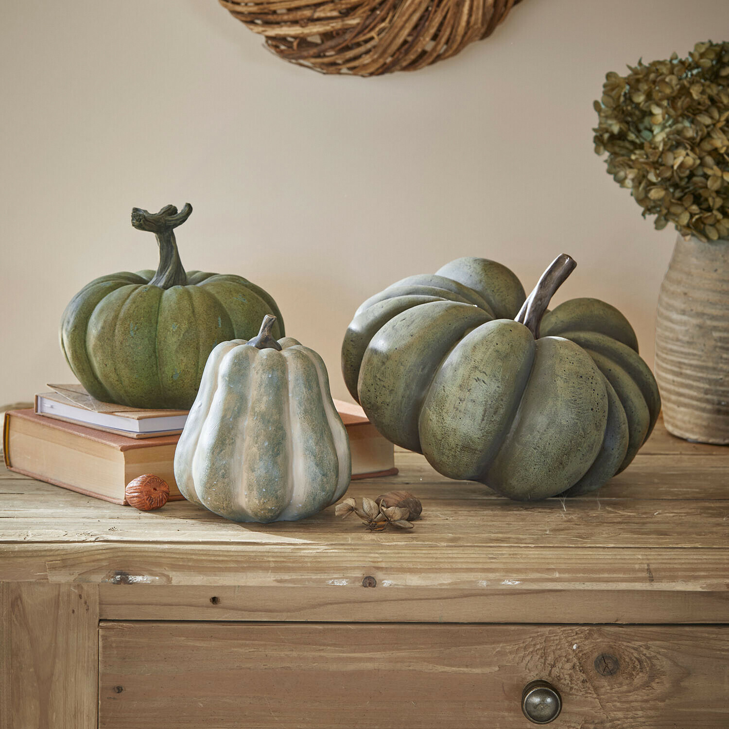 Lot de 3 citrouilles Veronira Citrouilles décoratives vertes et blanches posées sur une table en bois avec livres et fleurs séchées