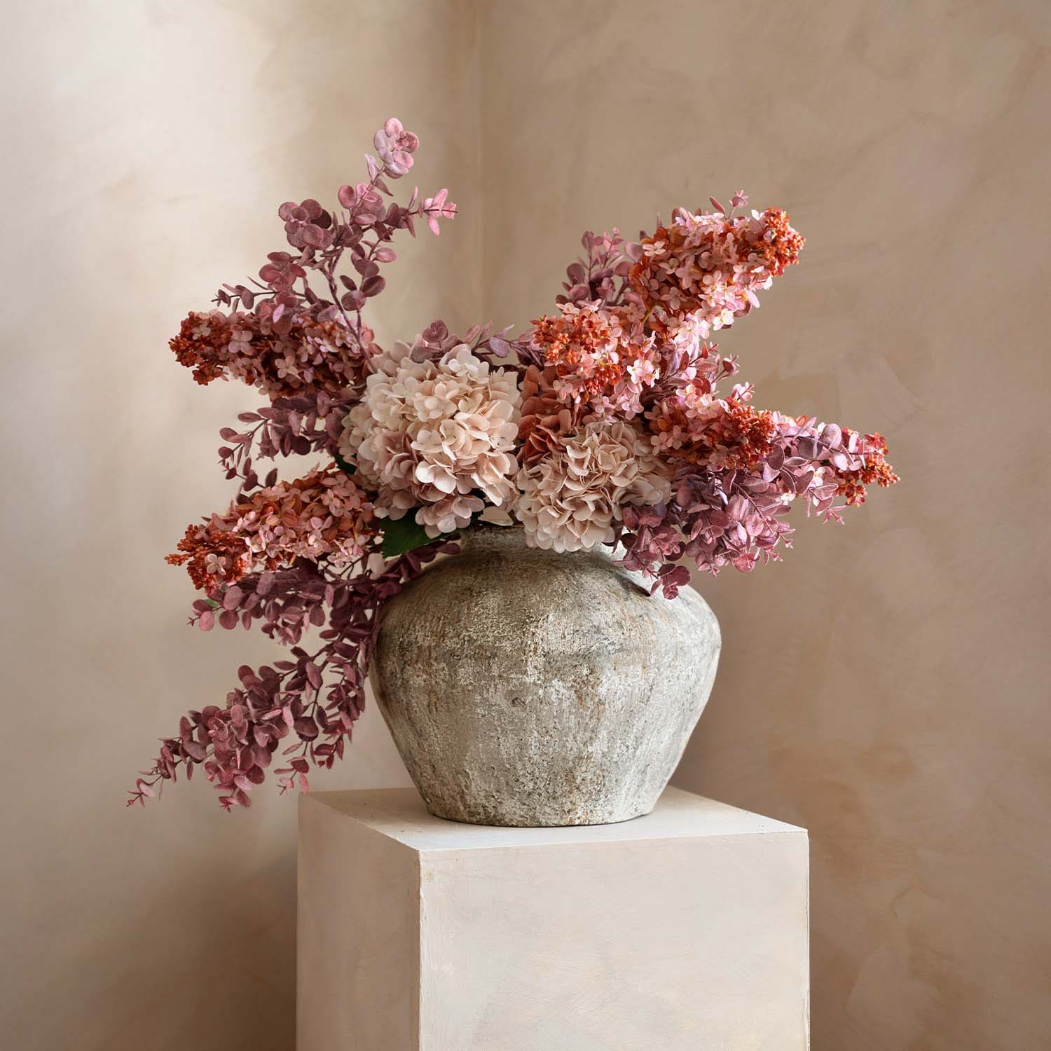Vase rustique en pierre avec bouquet de fleurs décoratives roses et beige pour décoration intérieure