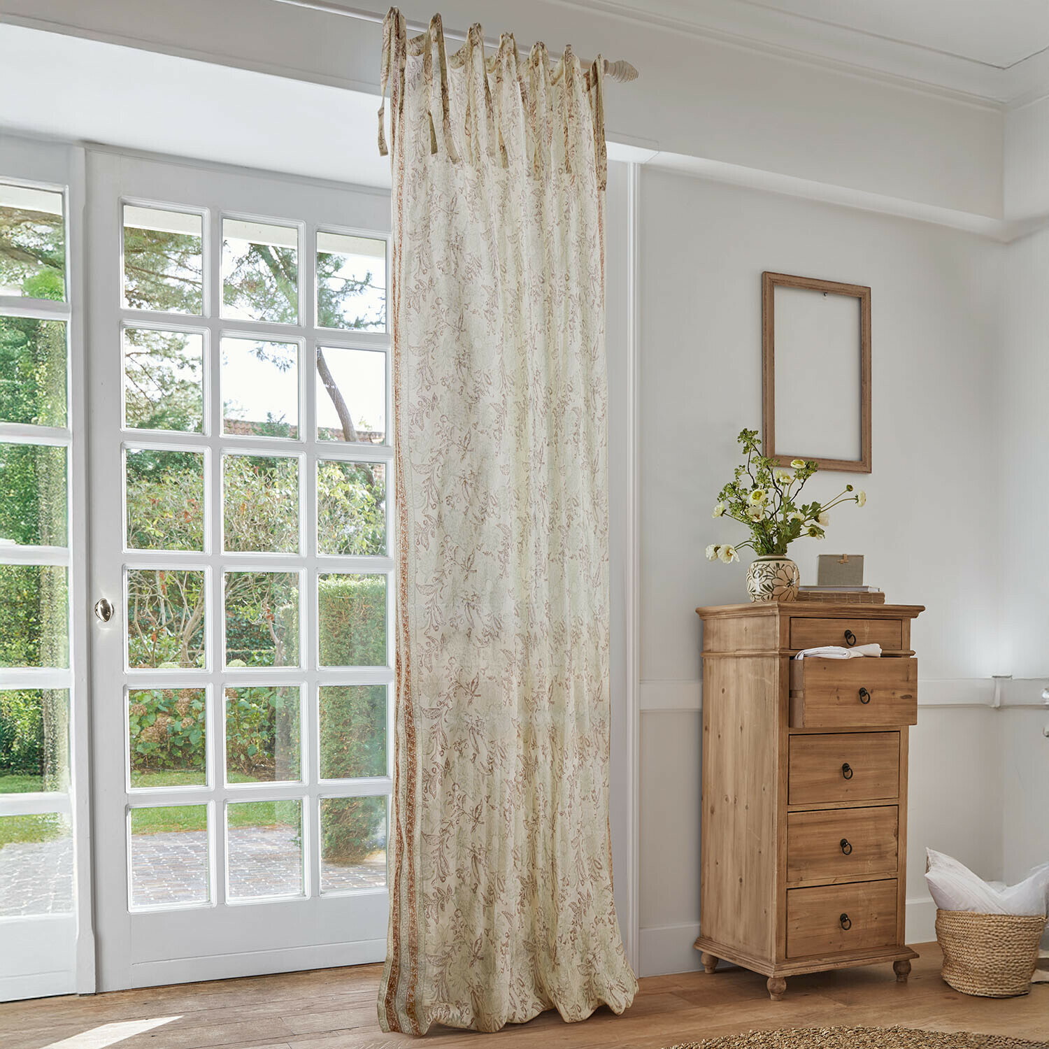 Rideau Floréane Rideau beige à motif floral délicat dans un salon lumineux avec commode en bois et grande fenêtre