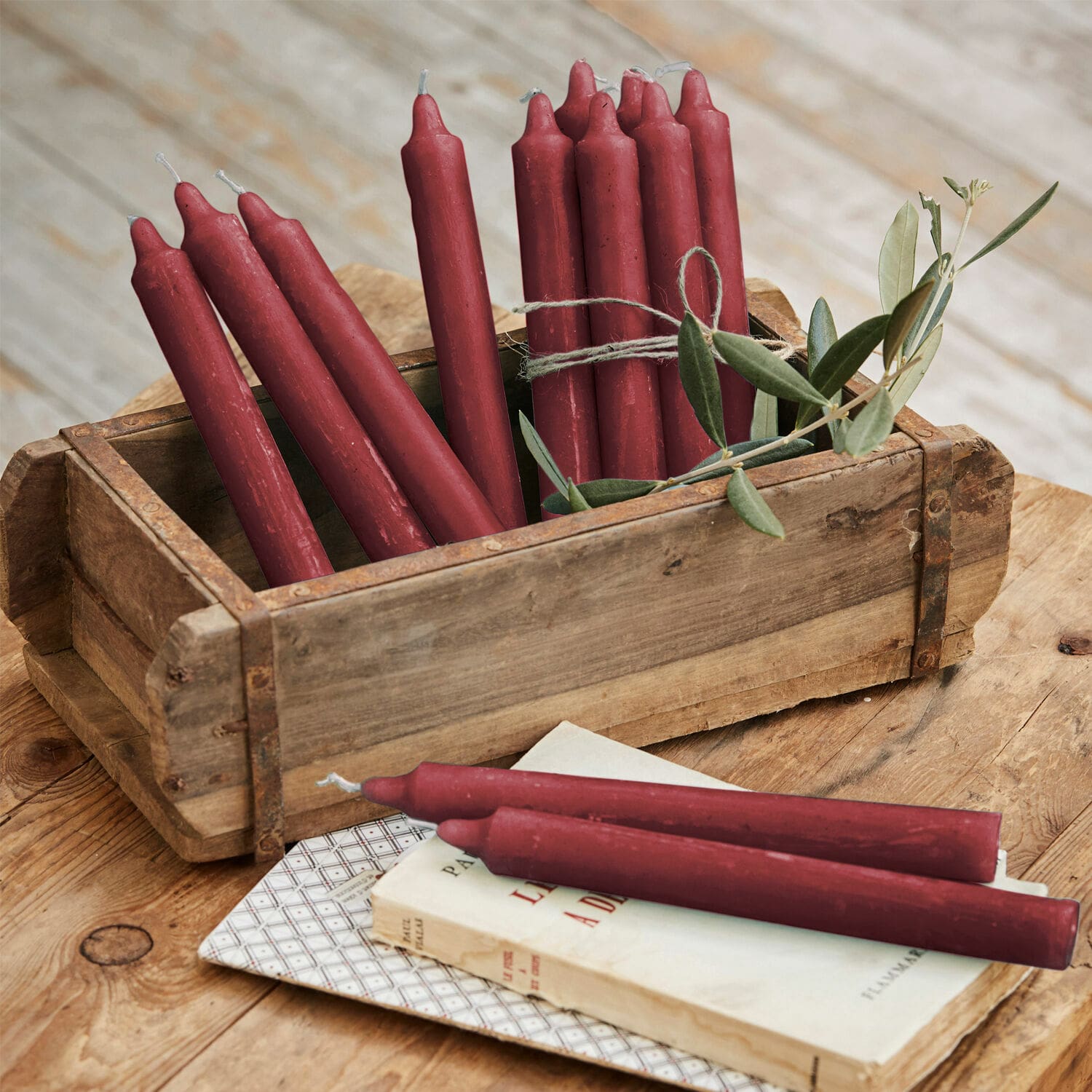 Lot de 12 bougies Bauceau Ensemble de bougies rouges en cire dans une caisse en bois sur une table rustique