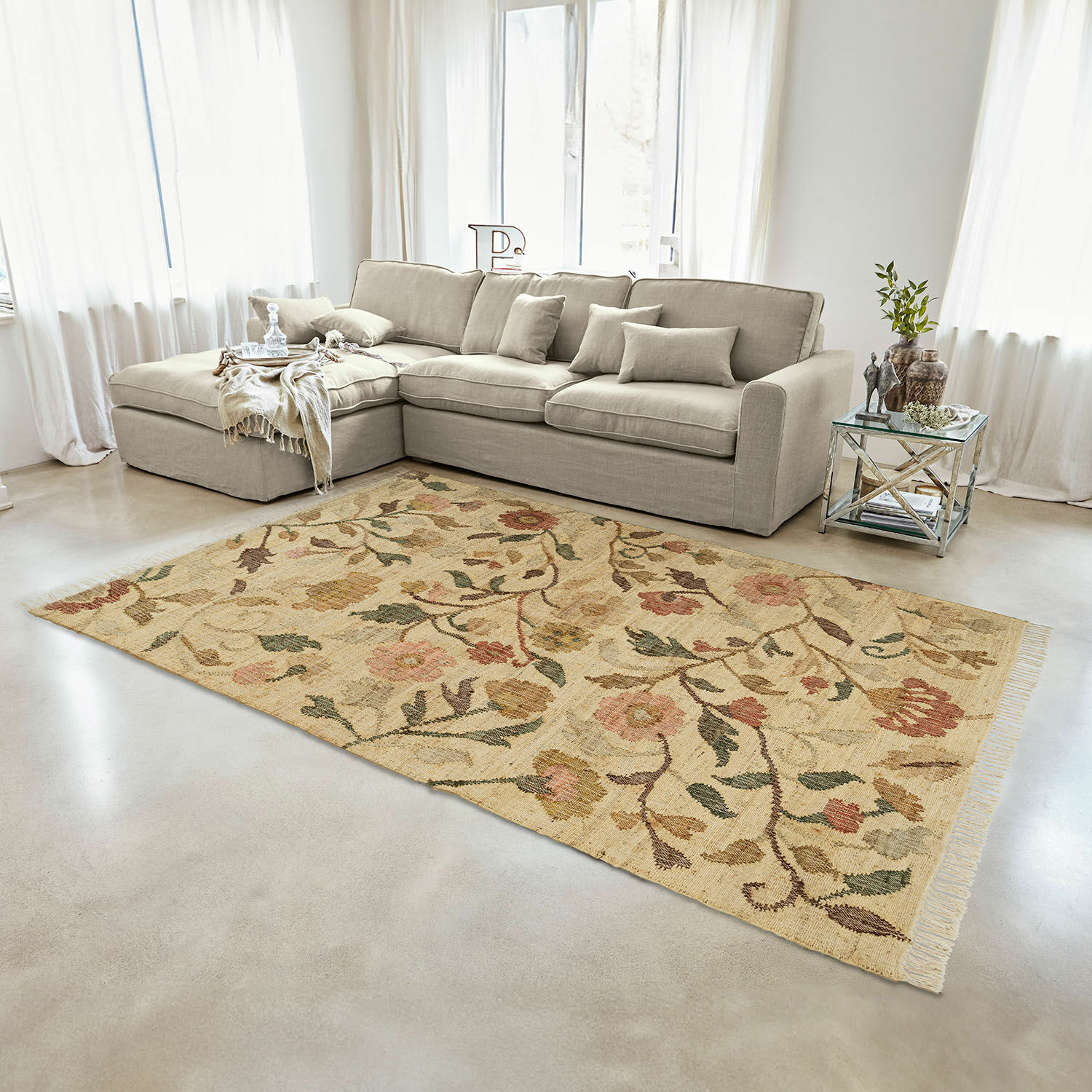 Tapis Théranelle Tapis beige en laine à motif floral dans un salon avec canapé gris et table d'appoint en verre