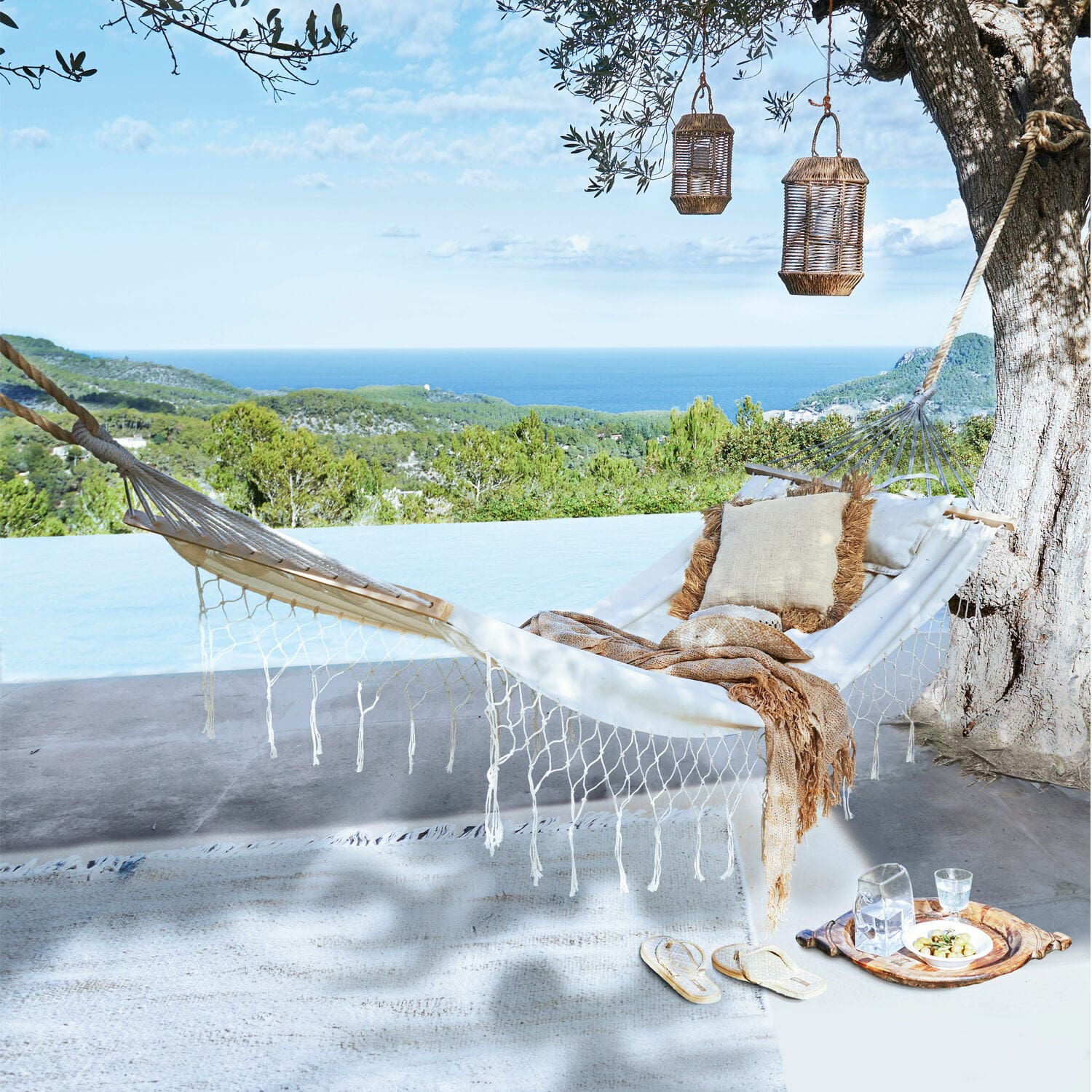 Hamac Moline Hamac blanc en coton avec coussin et plaid sur terrasse avec vue sur mer et forêt