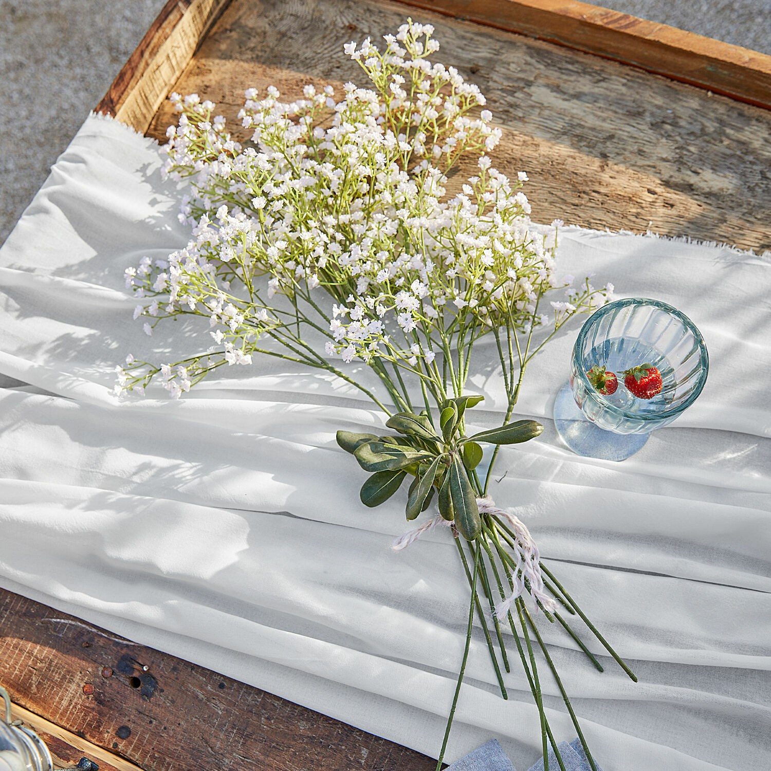 Bouquet décoratif Lorraine Bouquet de fleurs blanches sur tissu blanc posé sur une table en bois, décoration intérieure