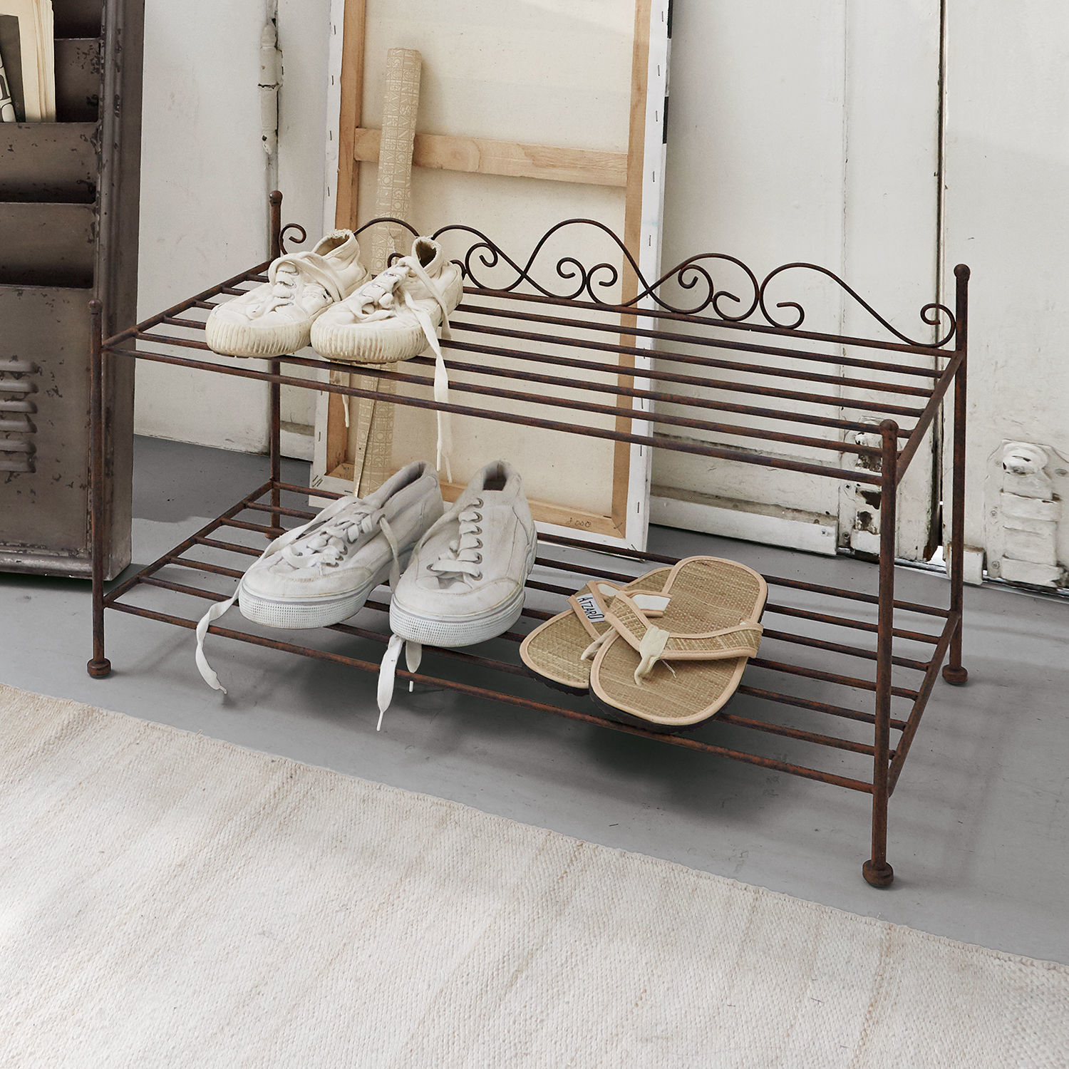 Meuble à chaussures Cloutier Étagère à chaussures en métal brun rouillé avec trois paires de chaussures claires dans un intérieur minimaliste