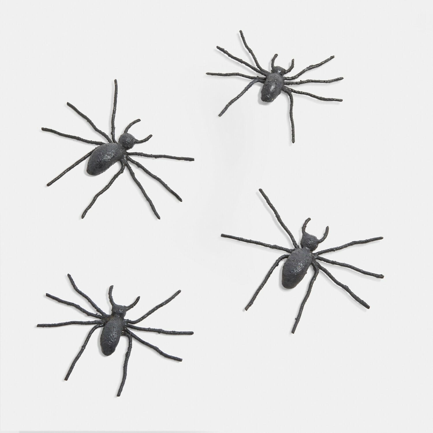 Lot de 4 araignées décoratives Gwynetha Quatre araignées décoratives noires en métal sur fond blanc, parfaites pour Halloween et décoration murale