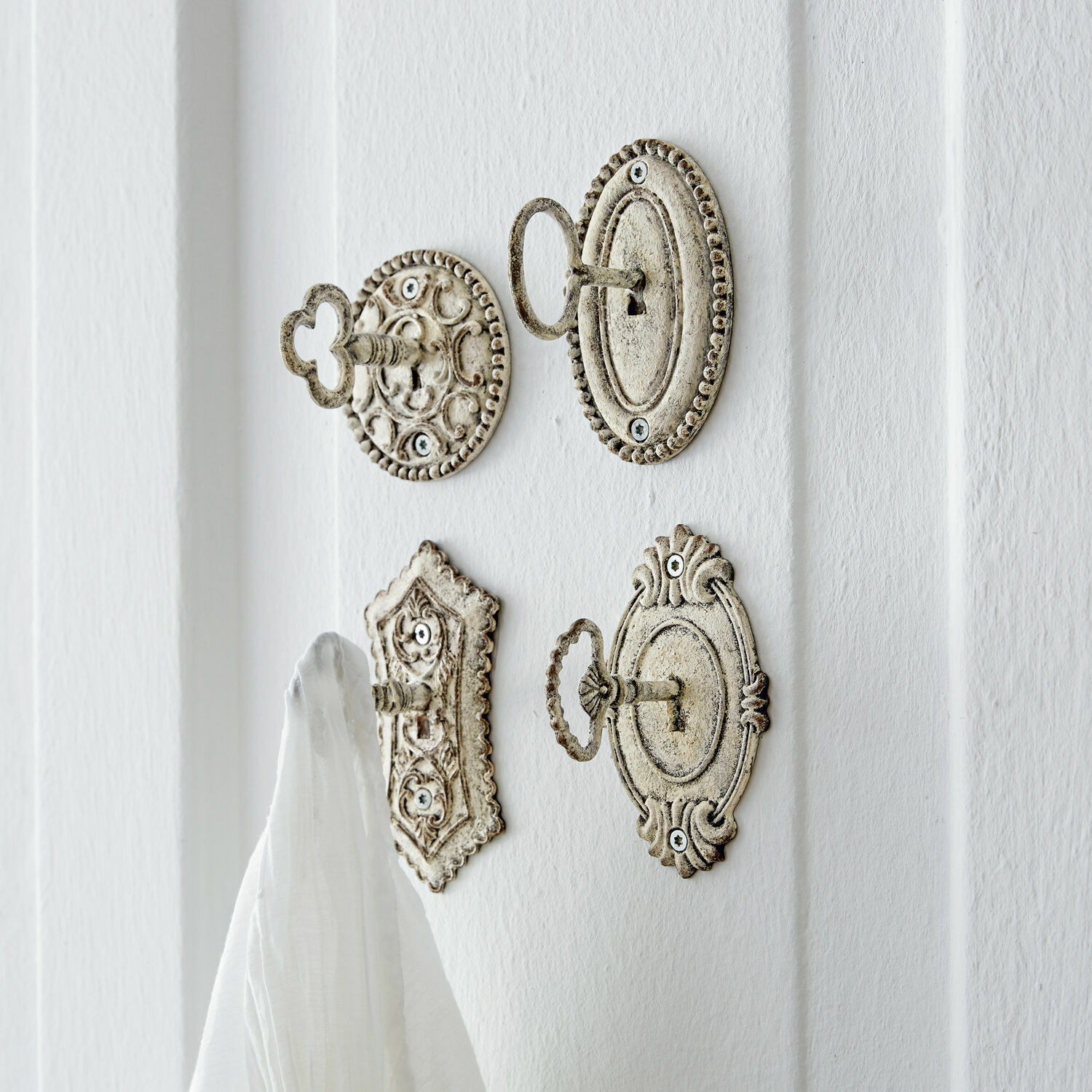 Lot de 4 patères Codrington Ensemble de quatre crochets en métal blanc vieilli pour suspendre serviettes et décorations murales