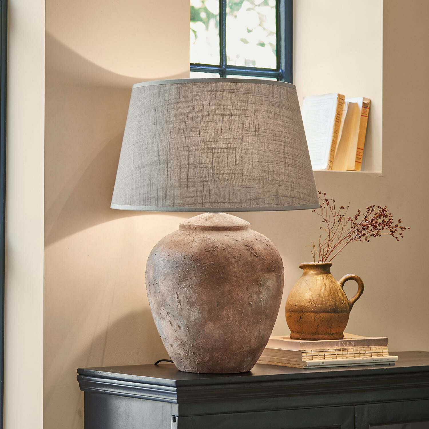 Lampe à poser Kelvador Lampe de table avec base en argile et abat-jour gris sur commode sombre dans un intérieur chaleureux
