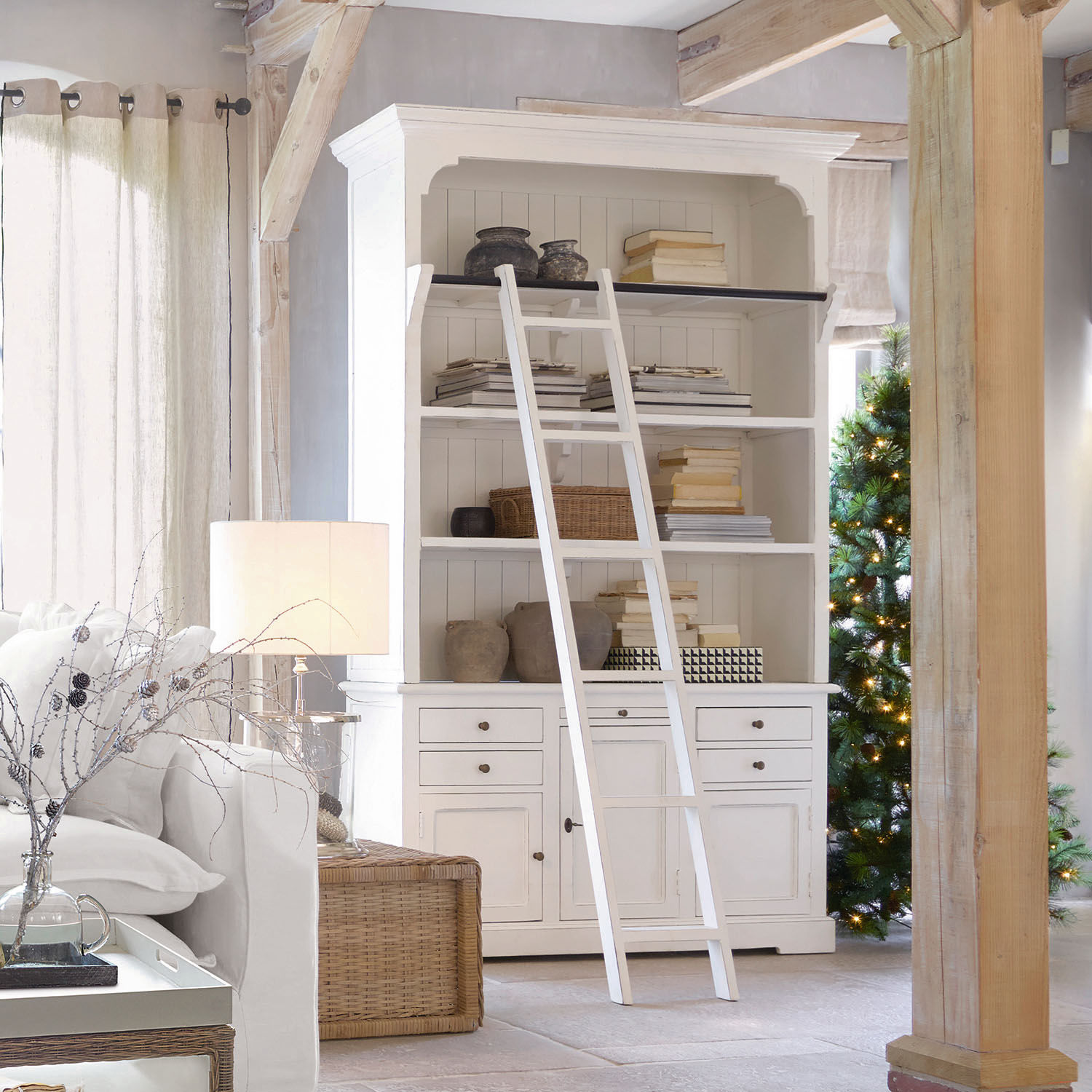 Buffet Monts Bibliothèque blanche en bois avec échelle et décorations dans un salon lumineux au style naturel