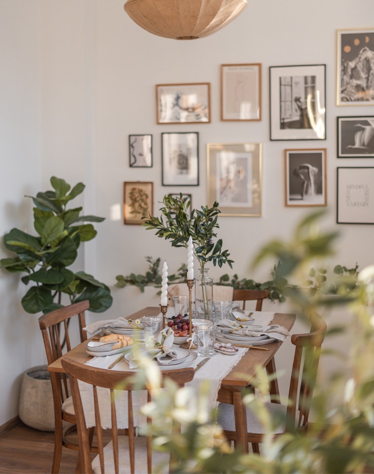 Salle à manger avec table et chaises en bois, décorations végétales et bougies, style naturel