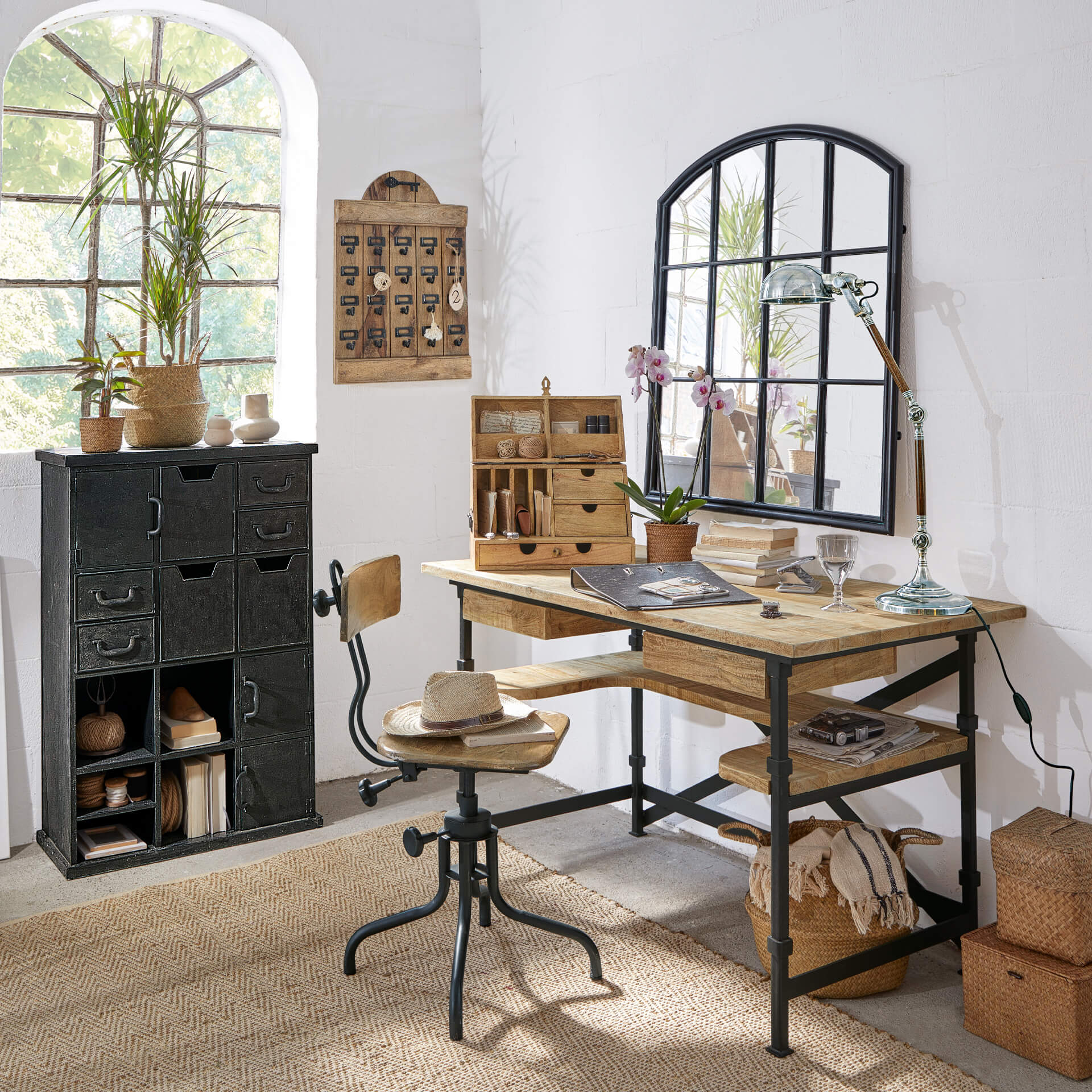Bureau et chaise en bois et métal style industriel dans une pièce lumineuse avec décorations et miroir