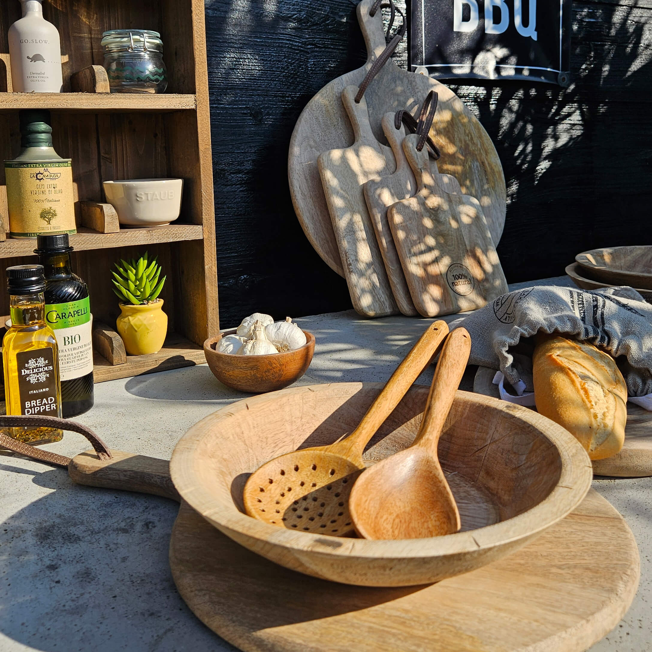 Ensemble de planches à découper et cuillères en bois sur table avec pain et huile d'olive