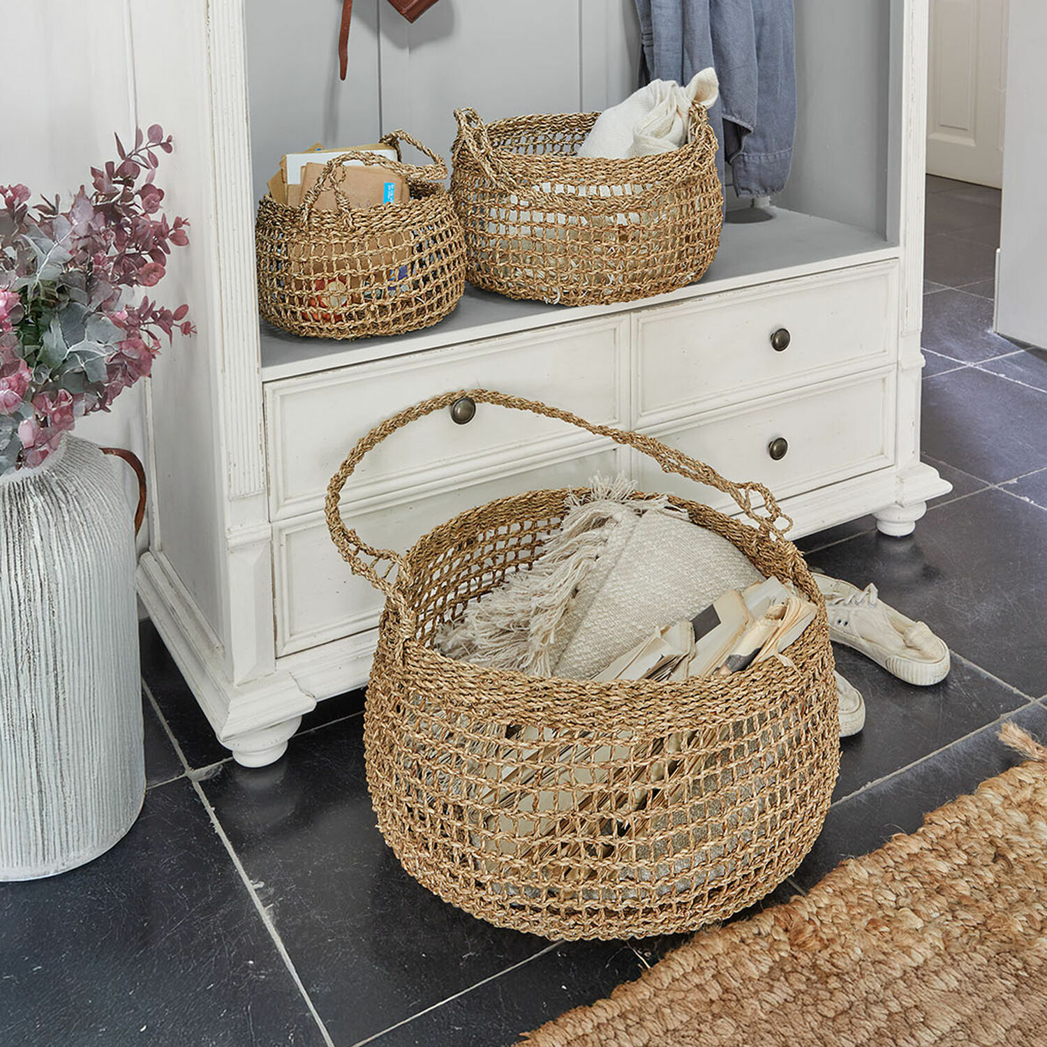 Lot de 3 corbeilles Ventourelle Trois paniers en osier couleur naturelle pour rangement dans un meuble clair sur sol noir