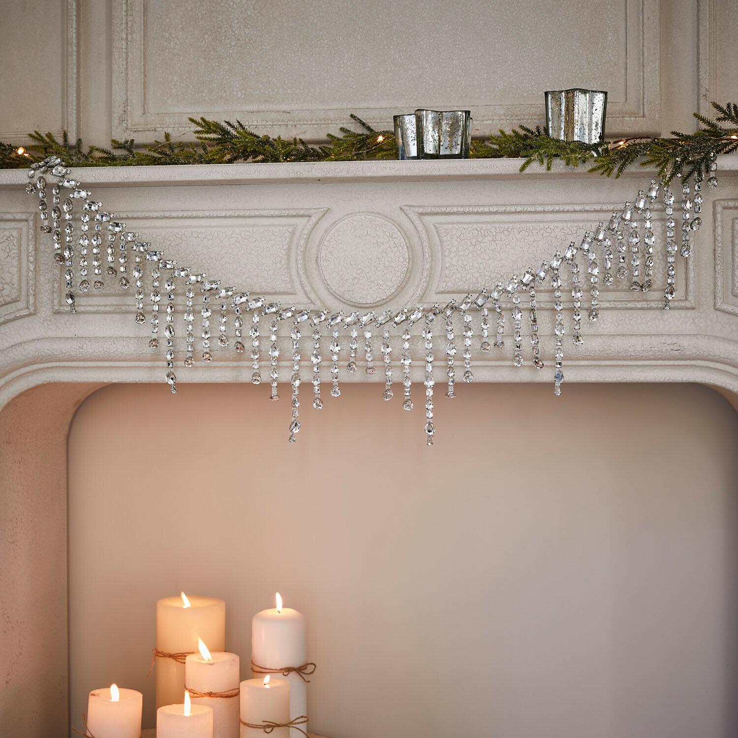 Guirlande Nastis Guirlande de cristaux décorative sur cheminée avec branches vertes et bougies allumées, décoration festive