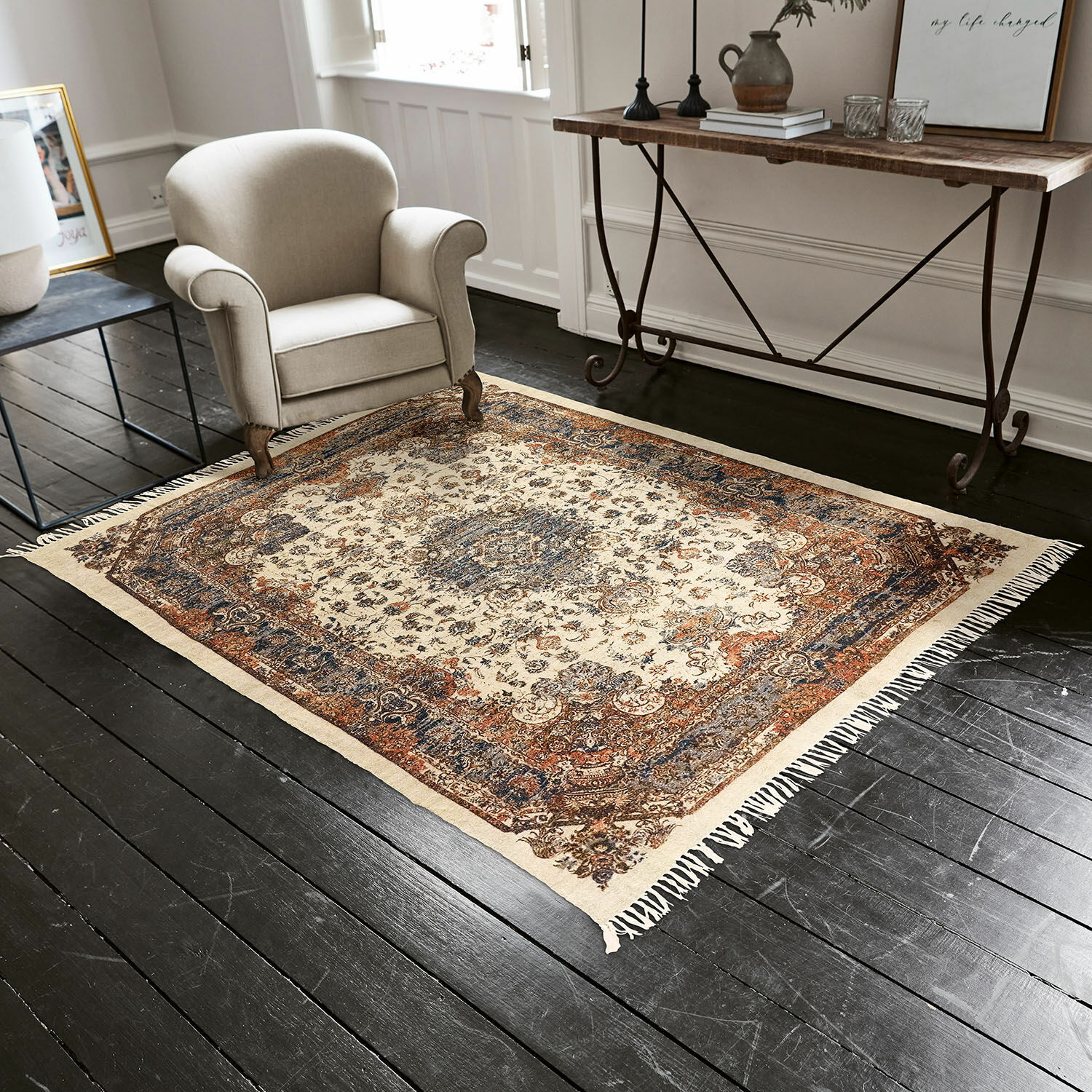 Tapis Aleixo Tapis à motif oriental beige, bleu et marron sur un sol foncé dans un salon élégant