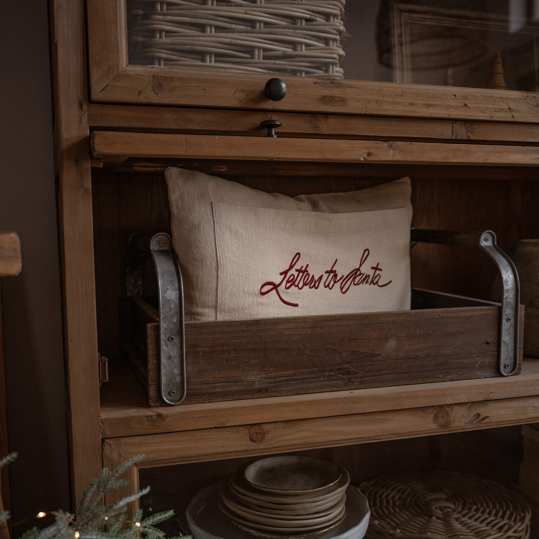 Coussin en lin beige avec inscription rouge Letters to Santa dans une caisse en bois sur une étagère