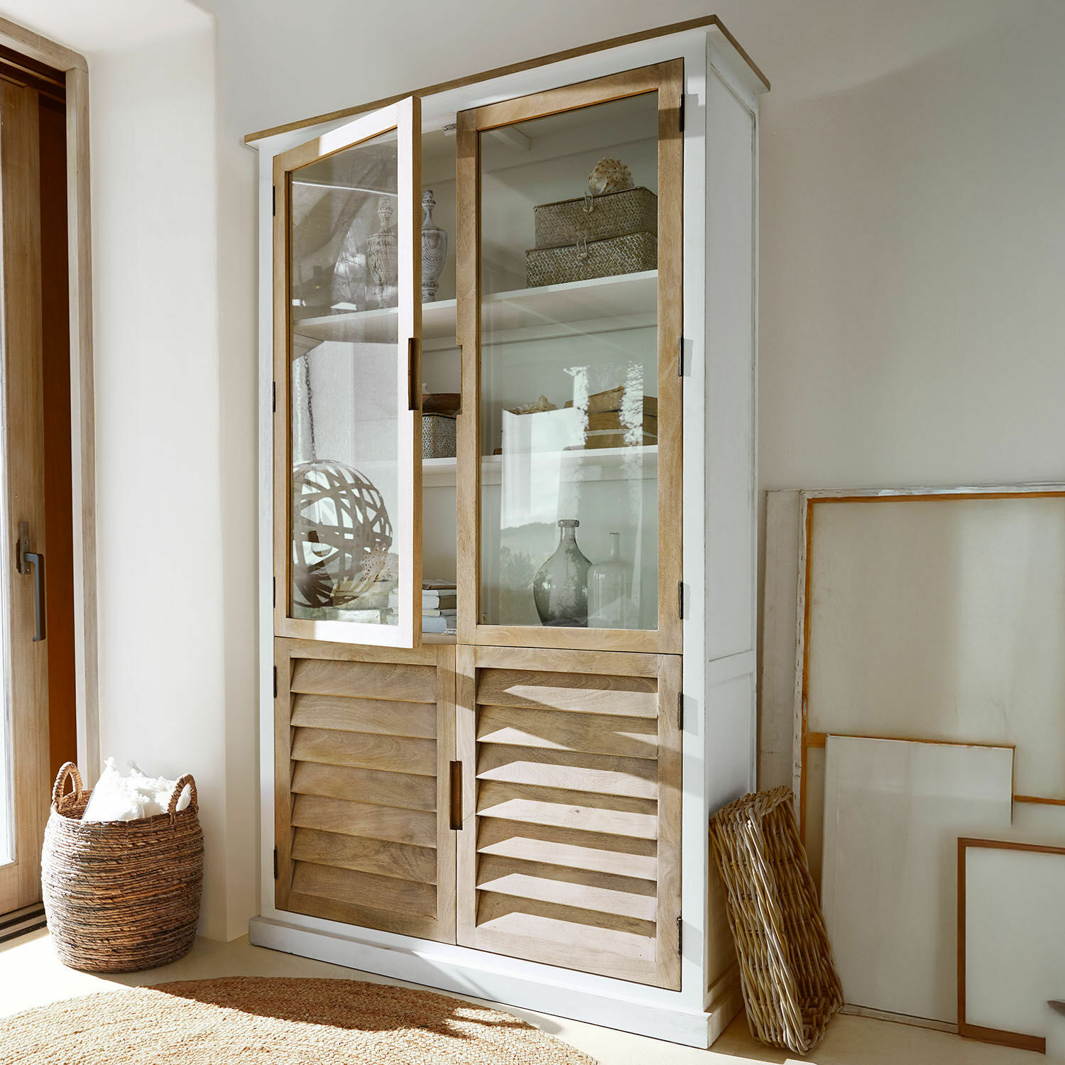 Armoire Frapelle Vitrine en bois blanc avec portes en bois clair et panneaux en verre dans un salon lumineux