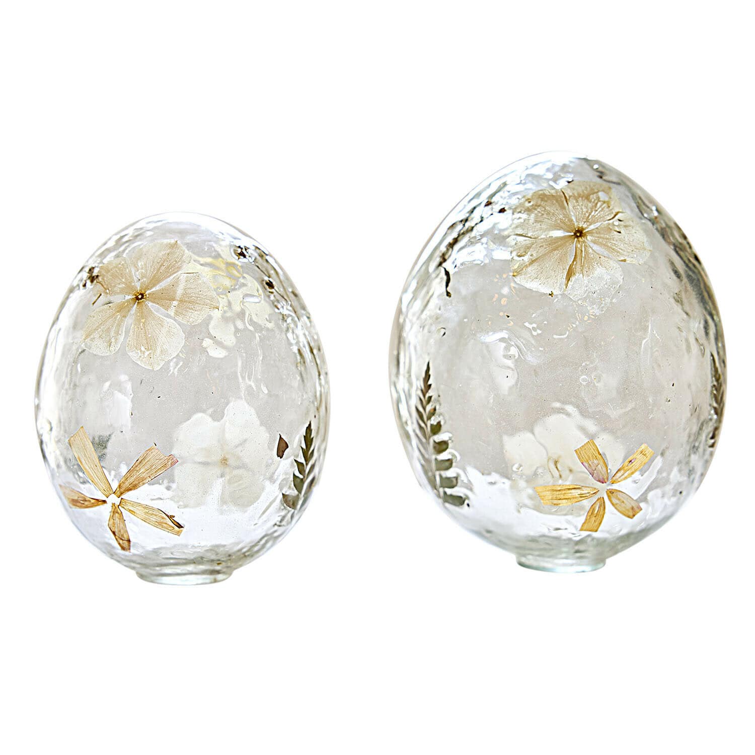 Deux œufs en verre transparent avec fleurs séchées et feuilles intégrées, décoration printanière