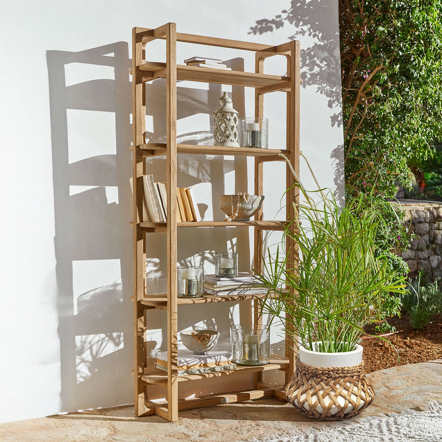 Étagère Alvoría Étagère en bois naturel avec décorations et plante en pot à l'extérieur au soleil
