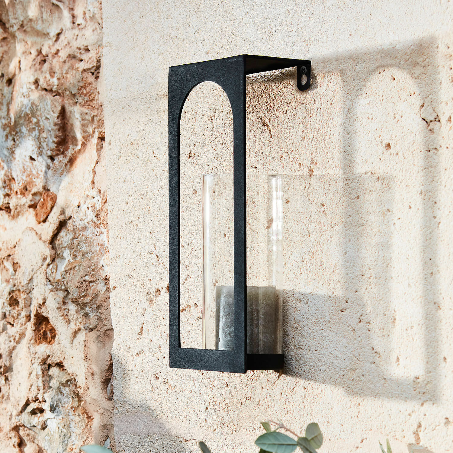 Bougeoir mural Maidis Applique murale noire en métal avec verre transparent et bougie sur mur en pierre beige