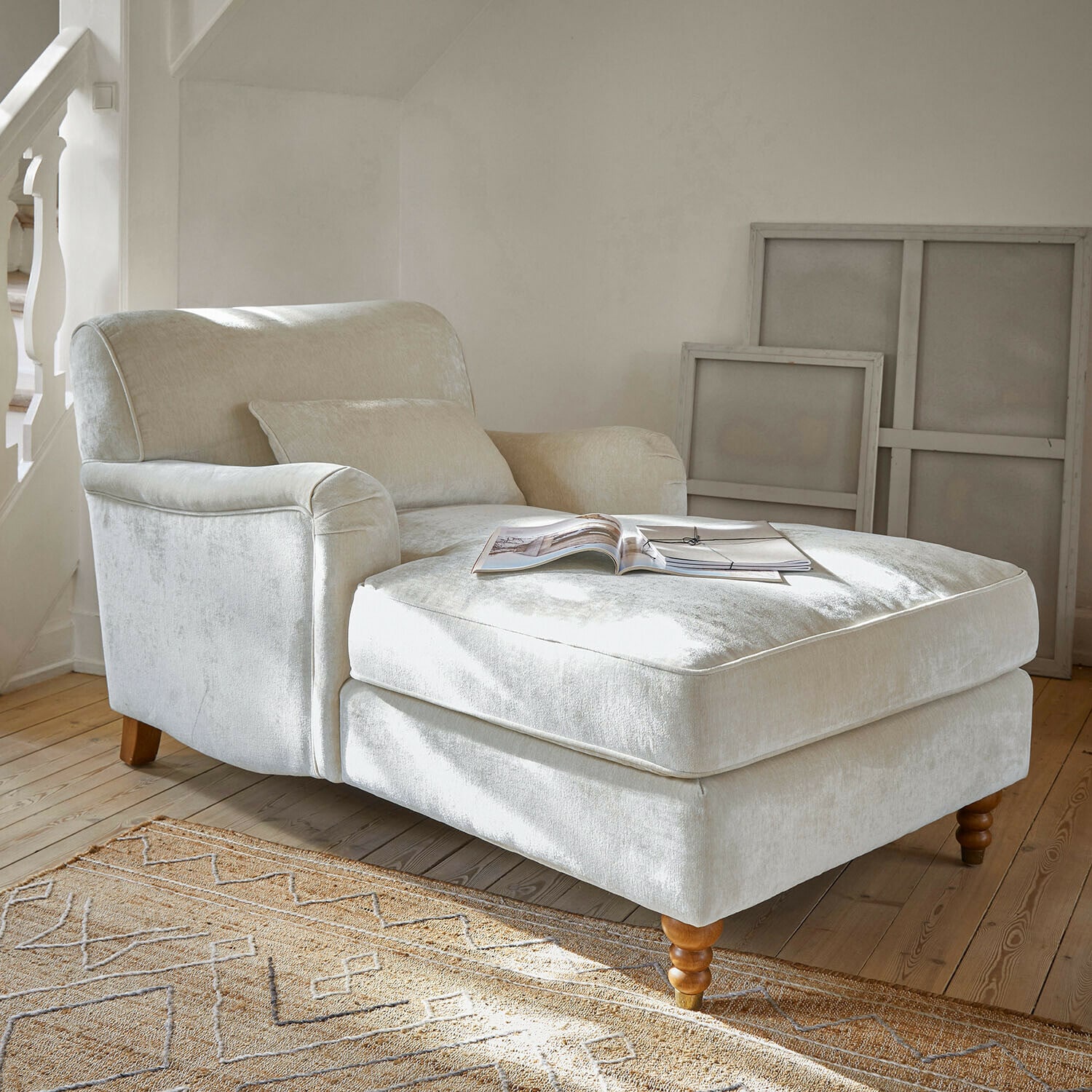 Méridienne Isa Fauteuil beige en tissu doux avec repose-pieds et pieds en bois dans un salon lumineux