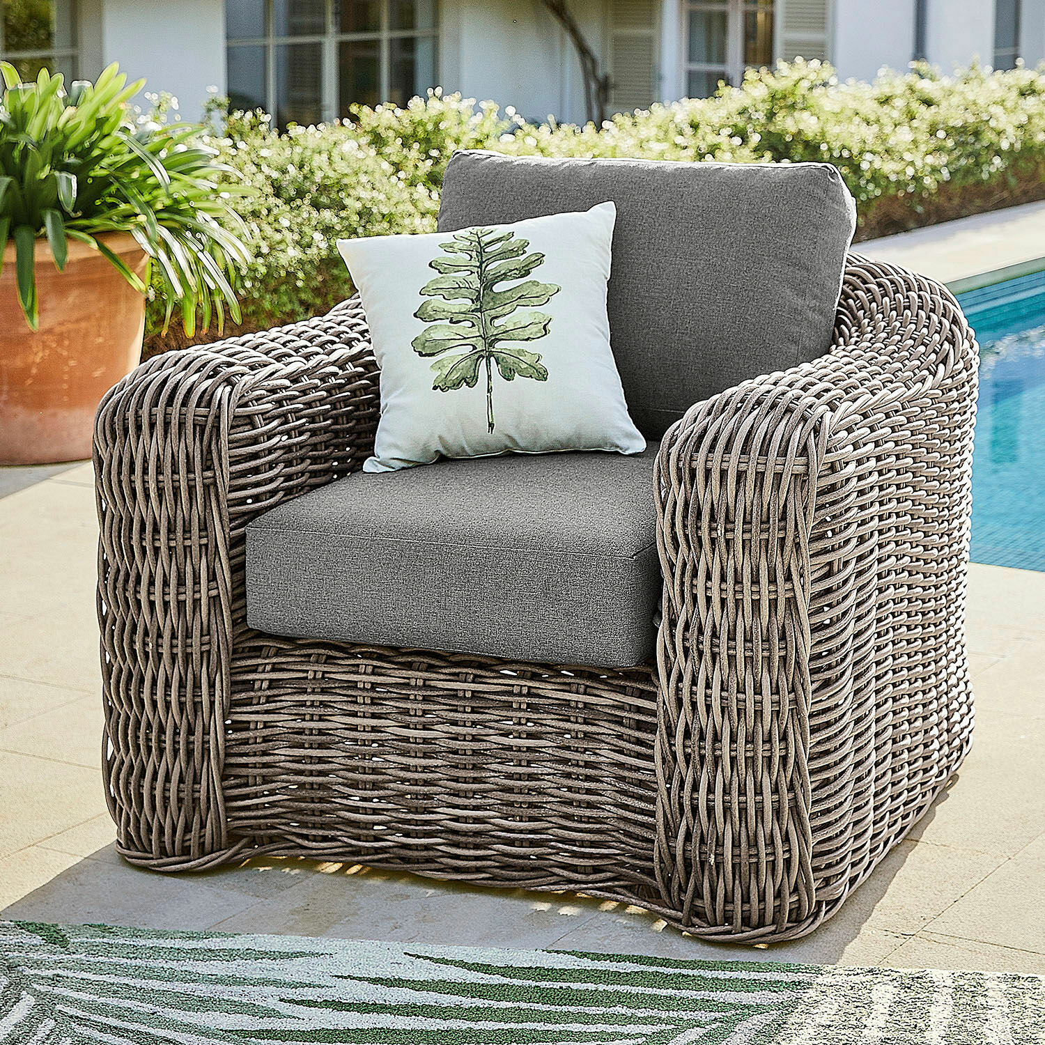 Fauteuil Upminster Fauteuil d'extérieur en rotin gris avec coussins gris et coussin décoratif à motif feuille verte