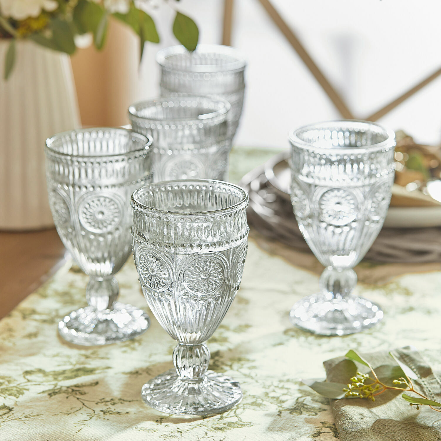 Lot de 6 verres Leatrice Ensemble de cinq verres transparents avec motif décoratif sur une table avec nappe verte