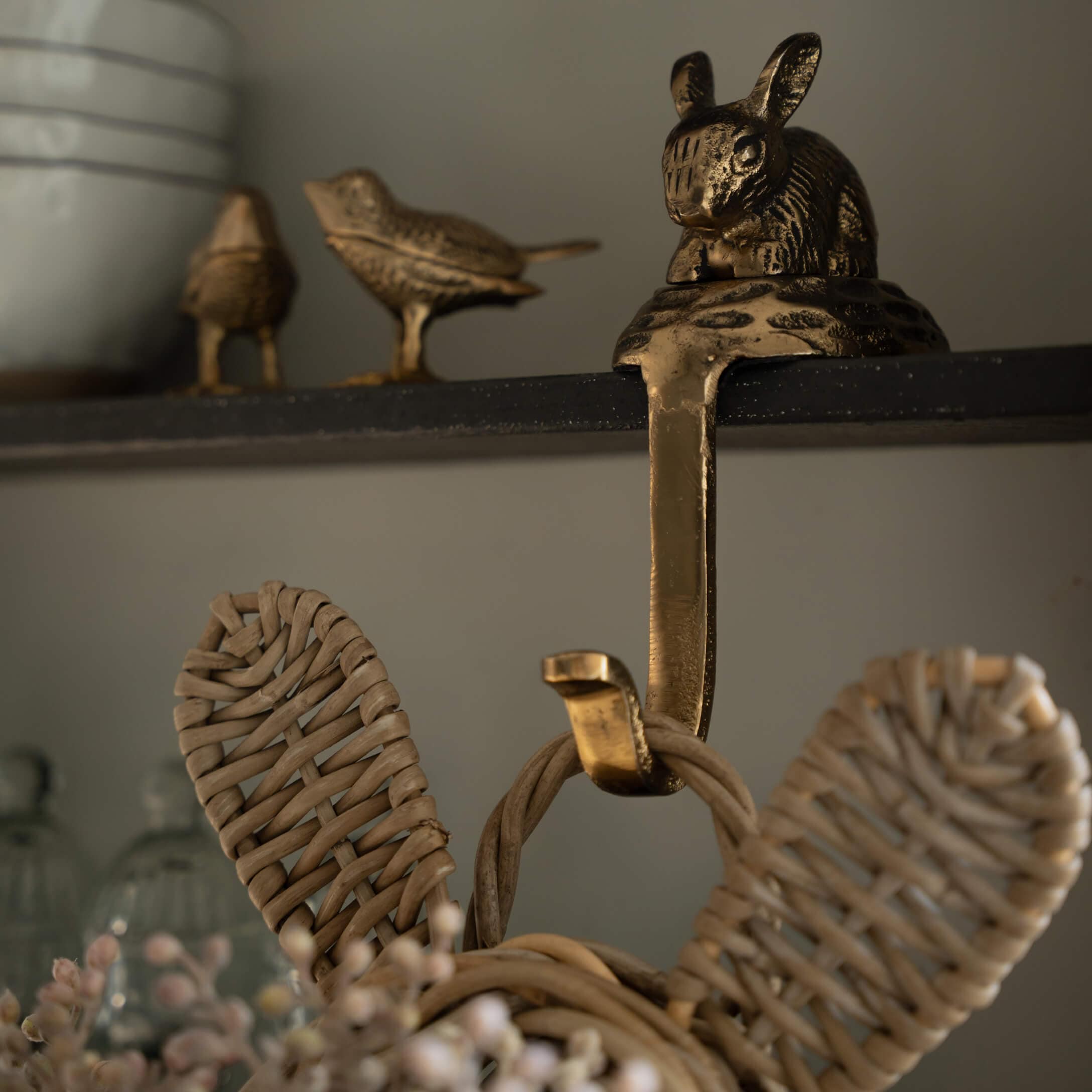Patère en laiton doré avec décoration lapin et oiseaux sur étagère noire pour intérieur