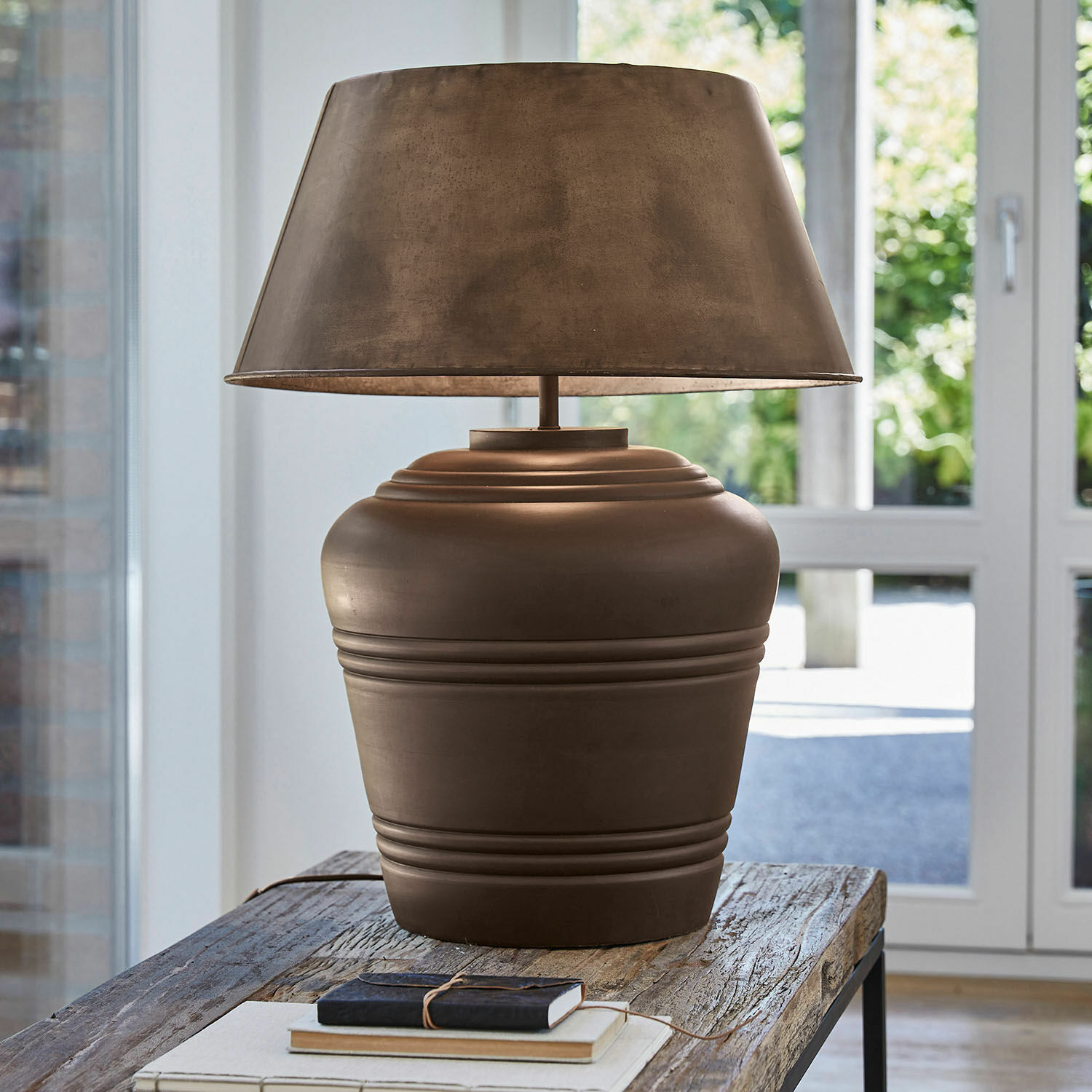 Lampe à poser Morice Lampe de table en céramique marron avec abat-jour posée sur une table en bois dans un intérieur lumineux