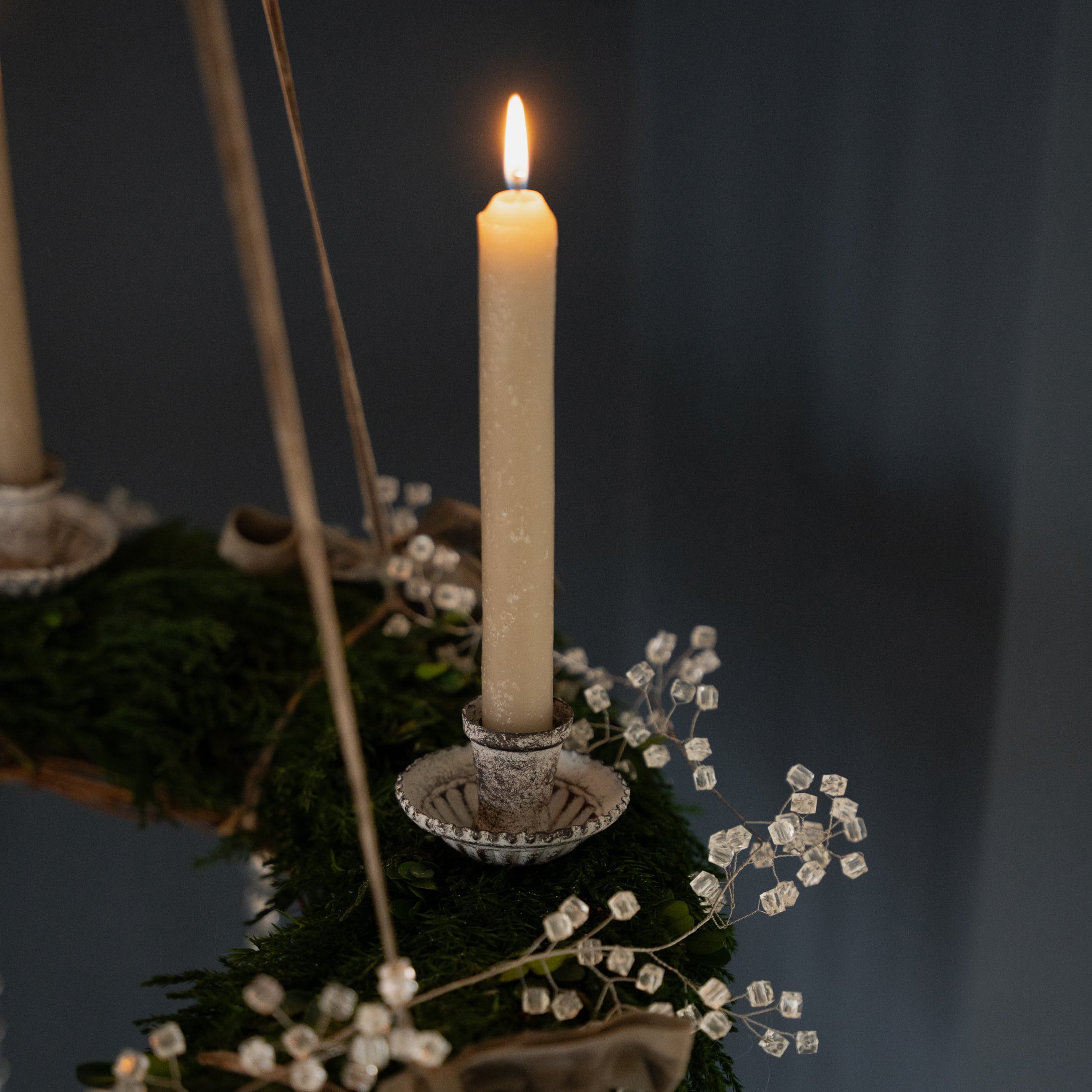 Bougeoir blanc en métal sur une couronne de l'Avent verte avec décorations en cristal