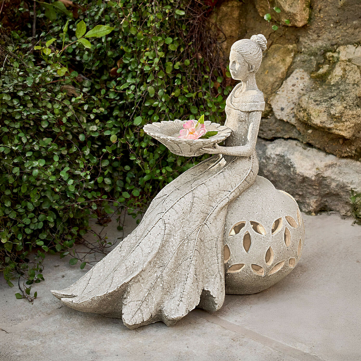Statue de jardin en pierre grise représentant une femme tenant un plat avec des fleurs, décoration extérieure