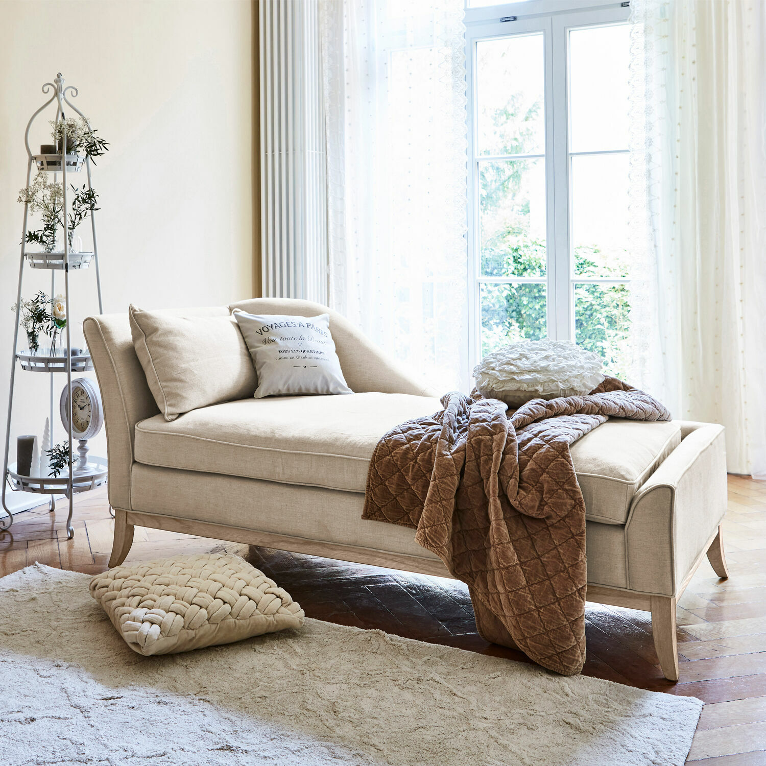 Méridienne Alphonse Chaise longue beige en tissu avec coussins et plaid marron dans un salon lumineux