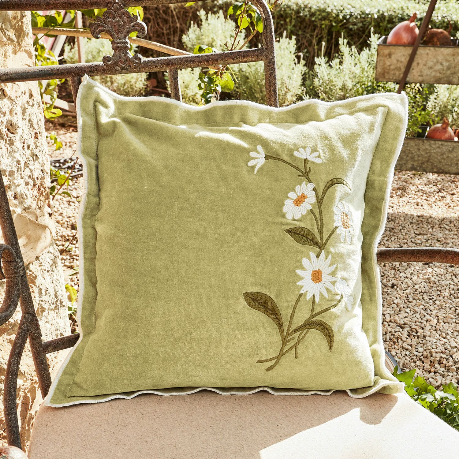 Coussin vert décoratif en tissu doux avec broderie de fleurs blanches, idéal pour intérieur et jardin