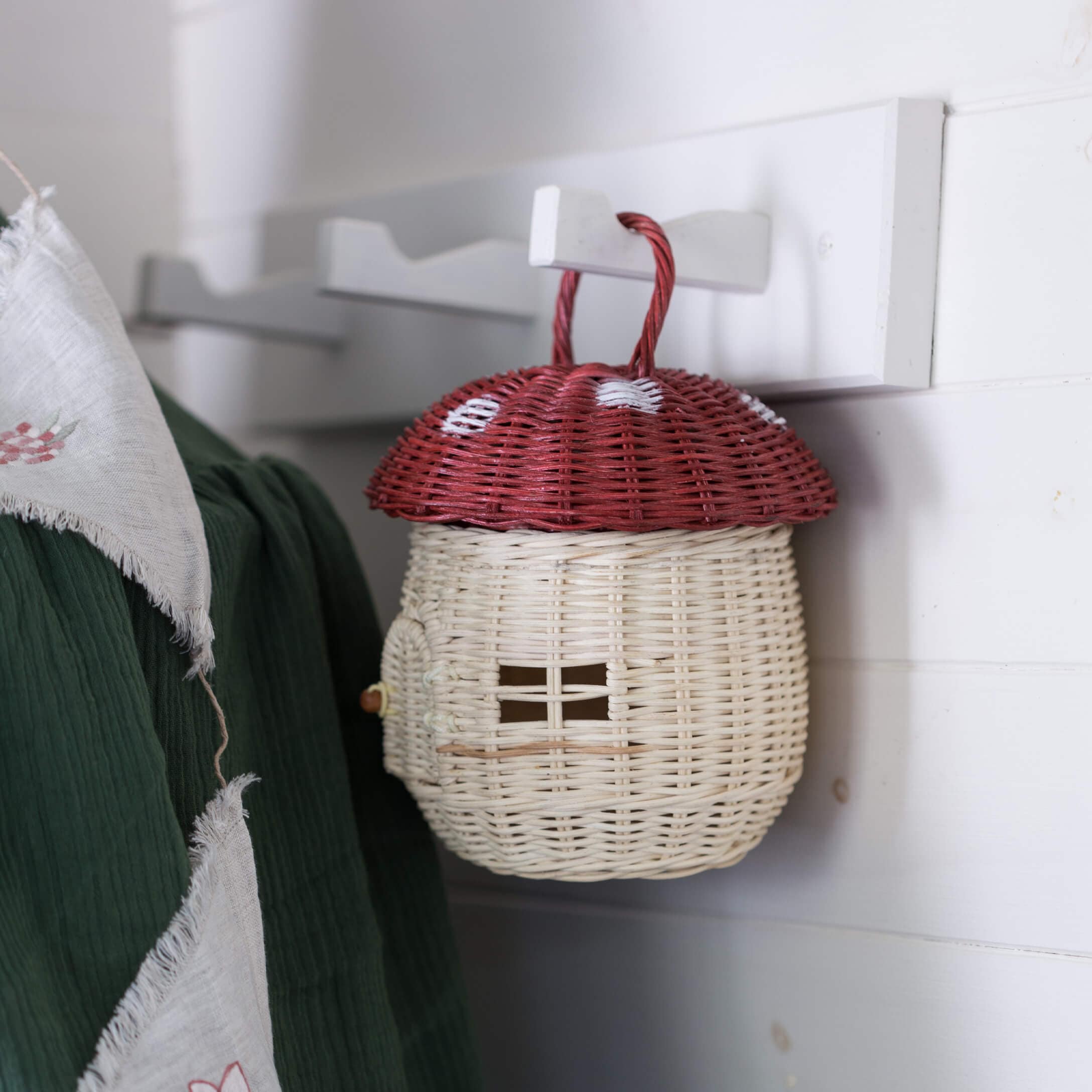 Panier décoratif en osier en forme de champignon rouge avec chapeau rouge et corps blanc suspendu à un crochet