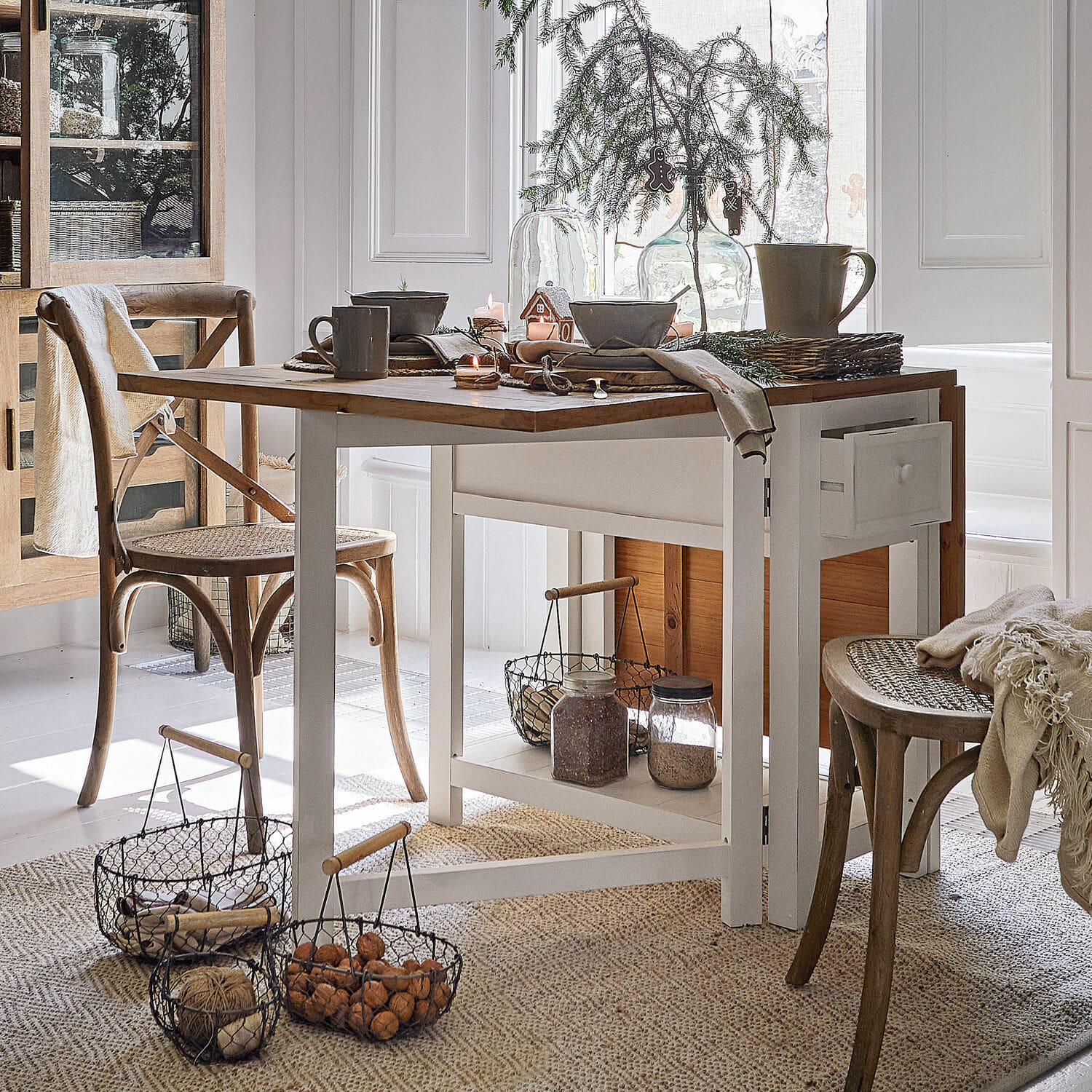 Table Dale Salle à manger avec table en bois blanc et chaises en osier naturel, décorations de Noël et paniers de noix
