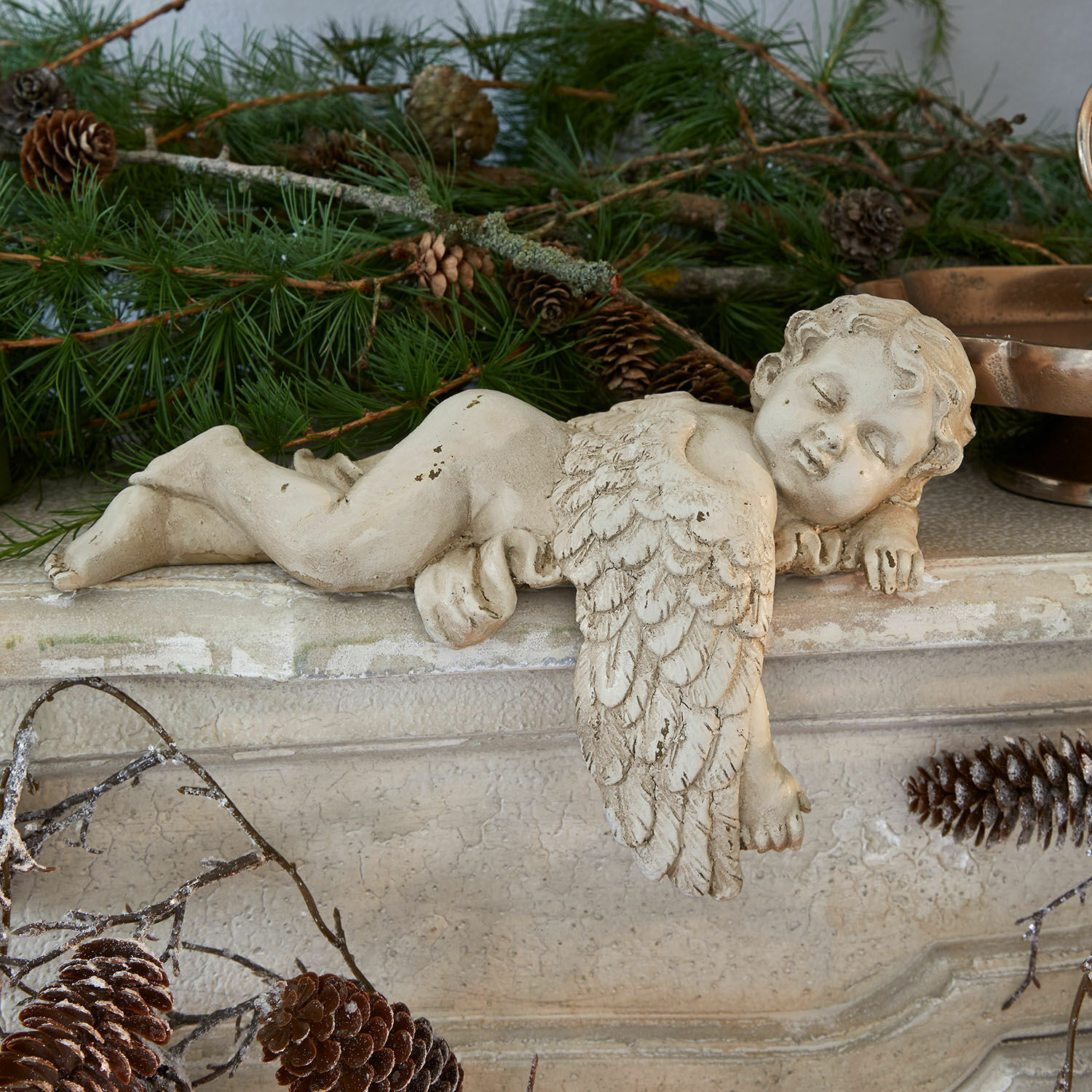 Ange décoratif Deronza Figurine d'ange en béton crème posée sur une cheminée avec branches de sapin et pommes de pin, décoration