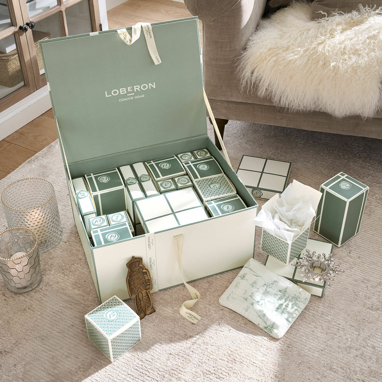 Calendrier de l’Avent Calavira Ensemble de boîtes vertes et blanches pour calendrier de l'Avent sur tapis beige près d'un canapé avec couverture en fourrure