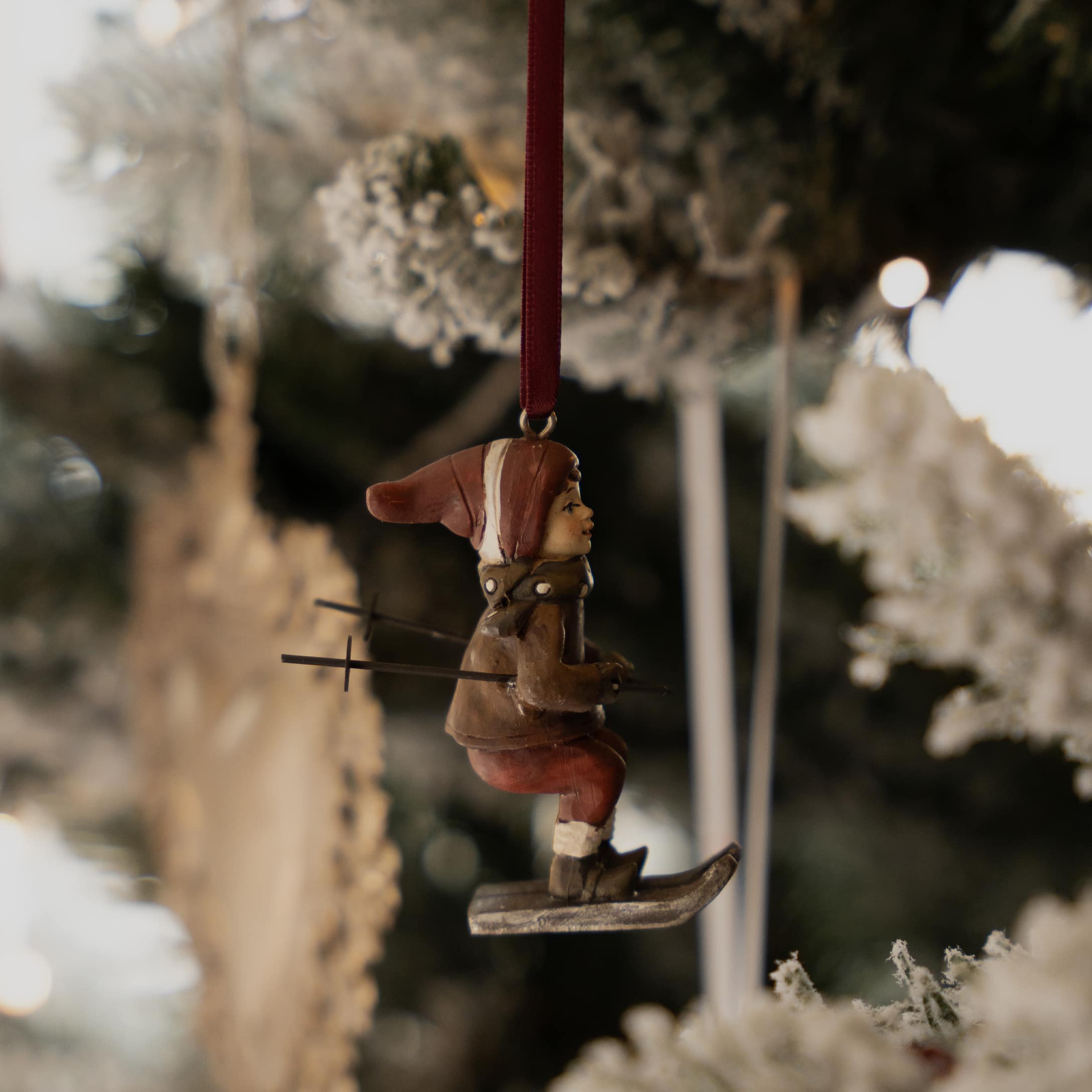 Décoration de sapin avec figurine de skieur en tenue marron et bonnet rouge pour Noël