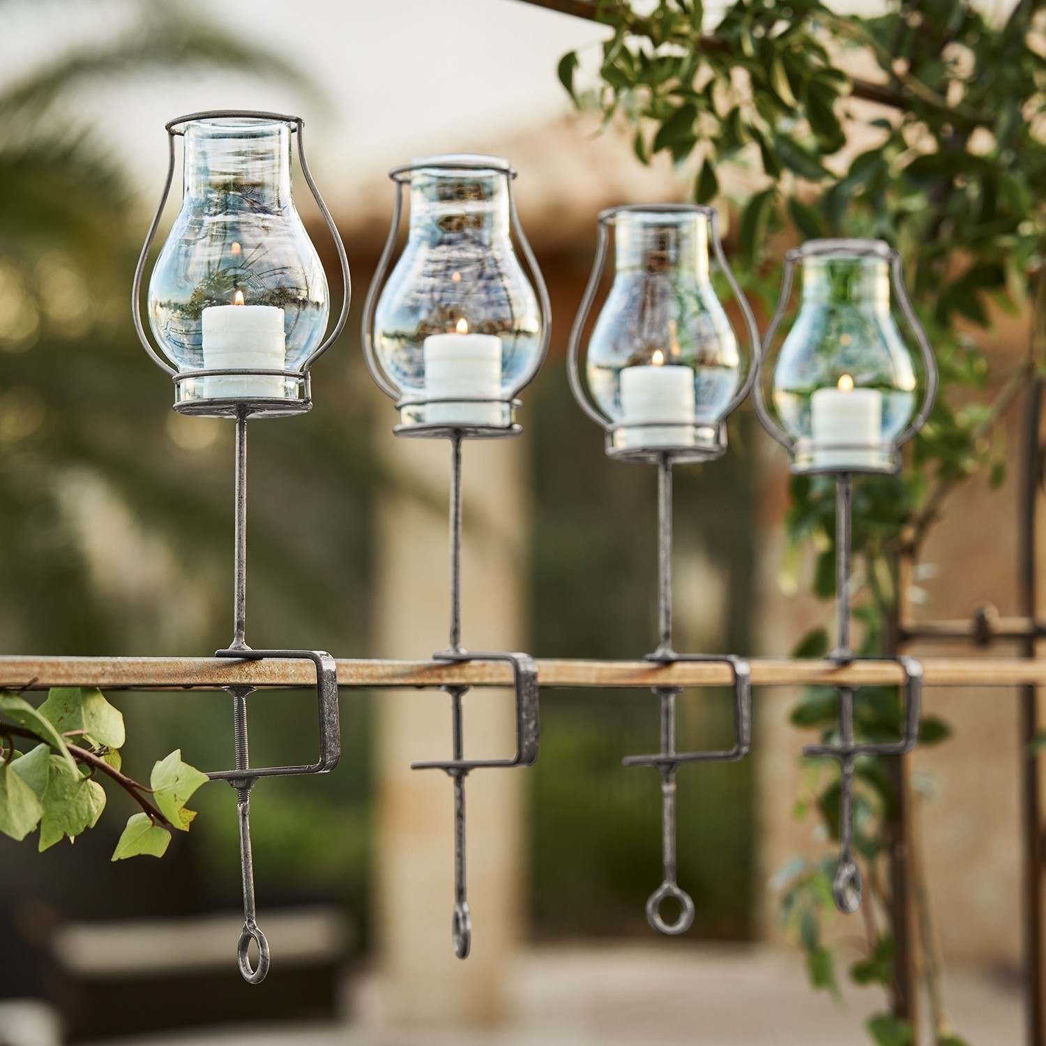 Lot de 4 photophores Calindra Ensemble de quatre lanternes en verre avec supports métalliques pour fixation sur rampe, décoration extérieure