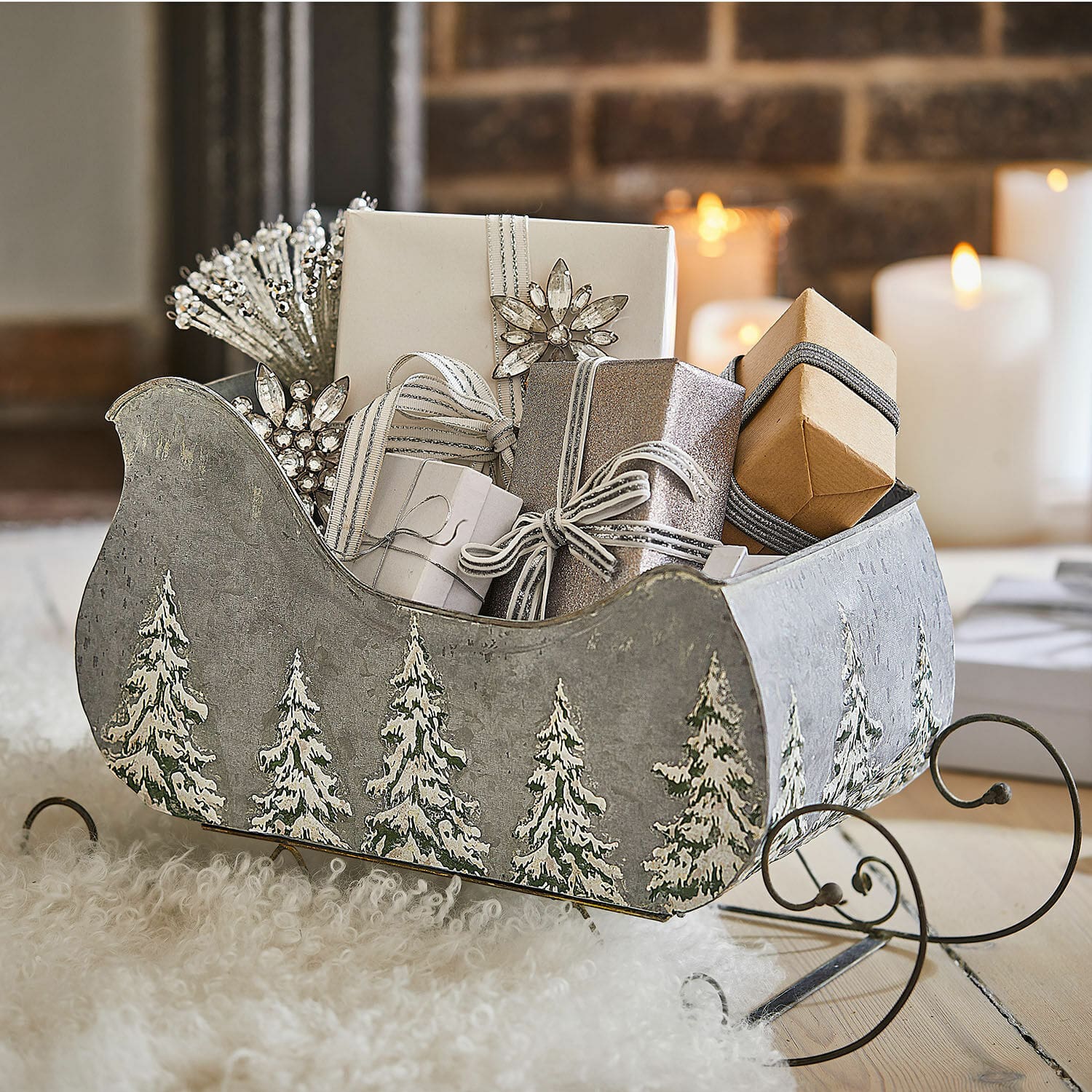 Traineau décoratif Pavie Luge en métal gris avec motif sapins, remplie de cadeaux et décorations de Noël