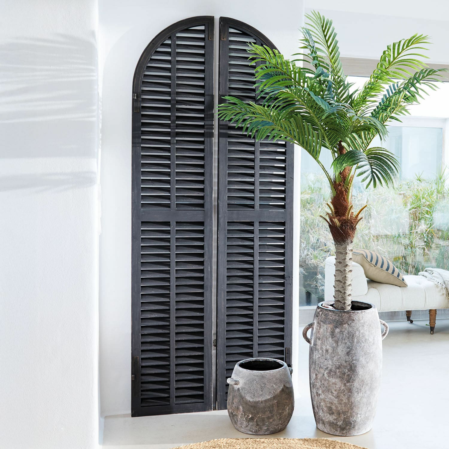Panneau décoratif Qixalvo Volets décoratifs en bois noir à arc dans un intérieur lumineux avec pots en pierre